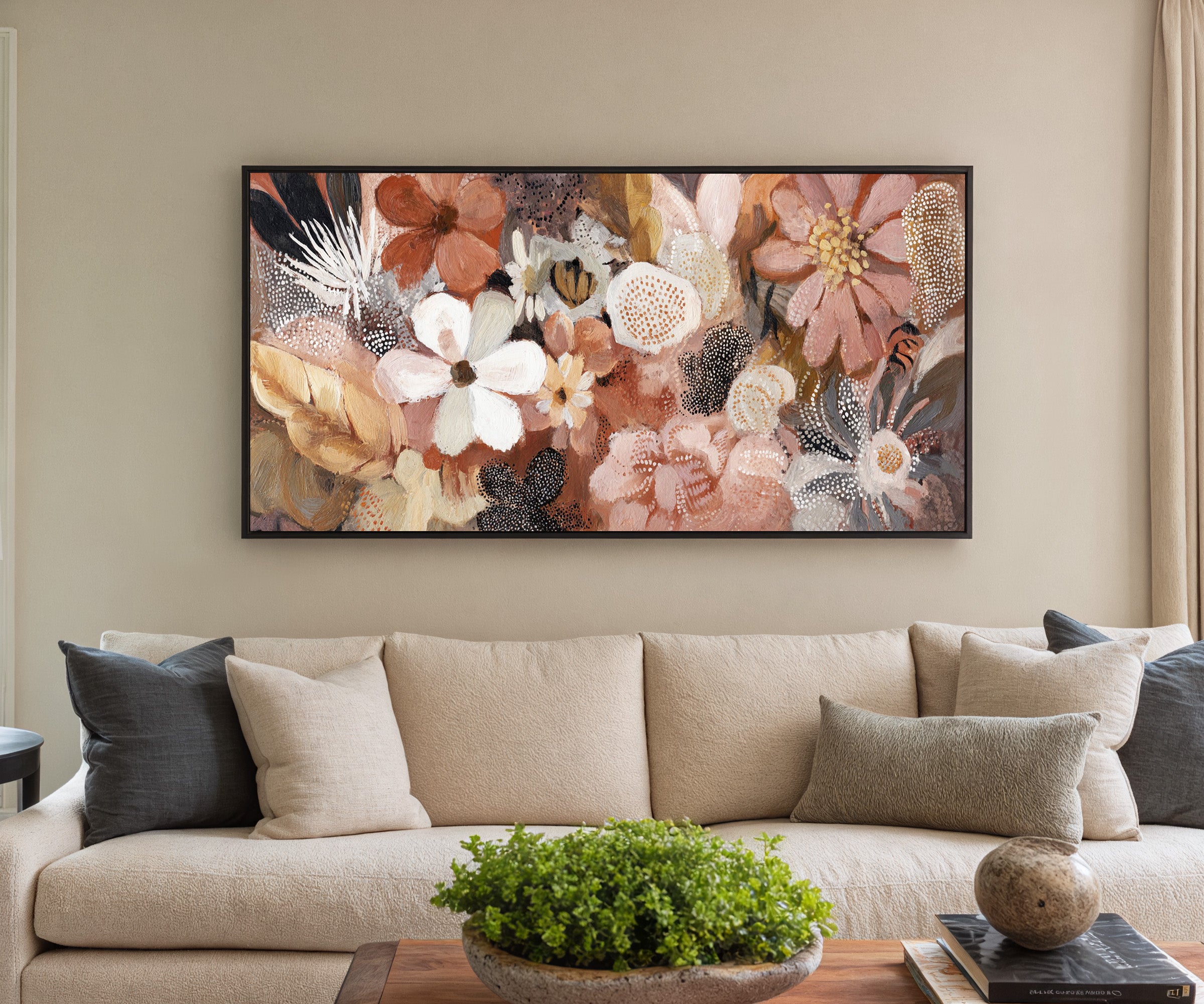 densely packed rounded flowers in blush, rust, canvas wall art in a black frame in a styled room setting
