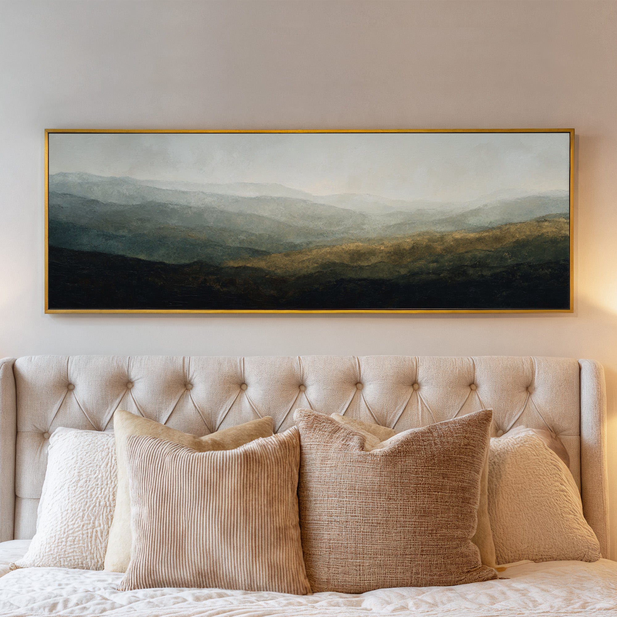 soft layered mountain landscape with diffused canvas wall art in a gold frame above a bed