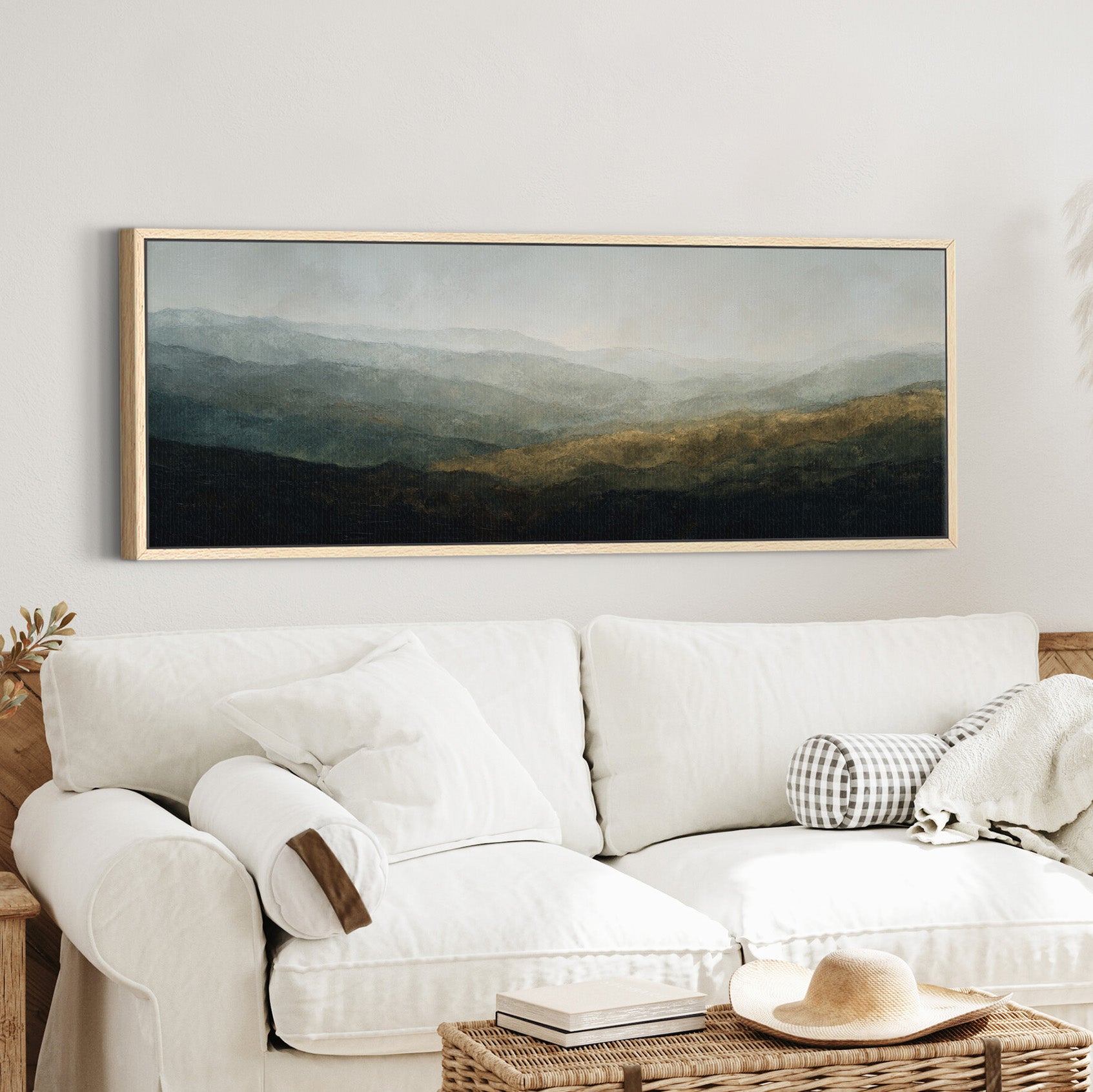 soft layered mountain landscape with diffused canvas wall art in an oak frame in a styled room setting