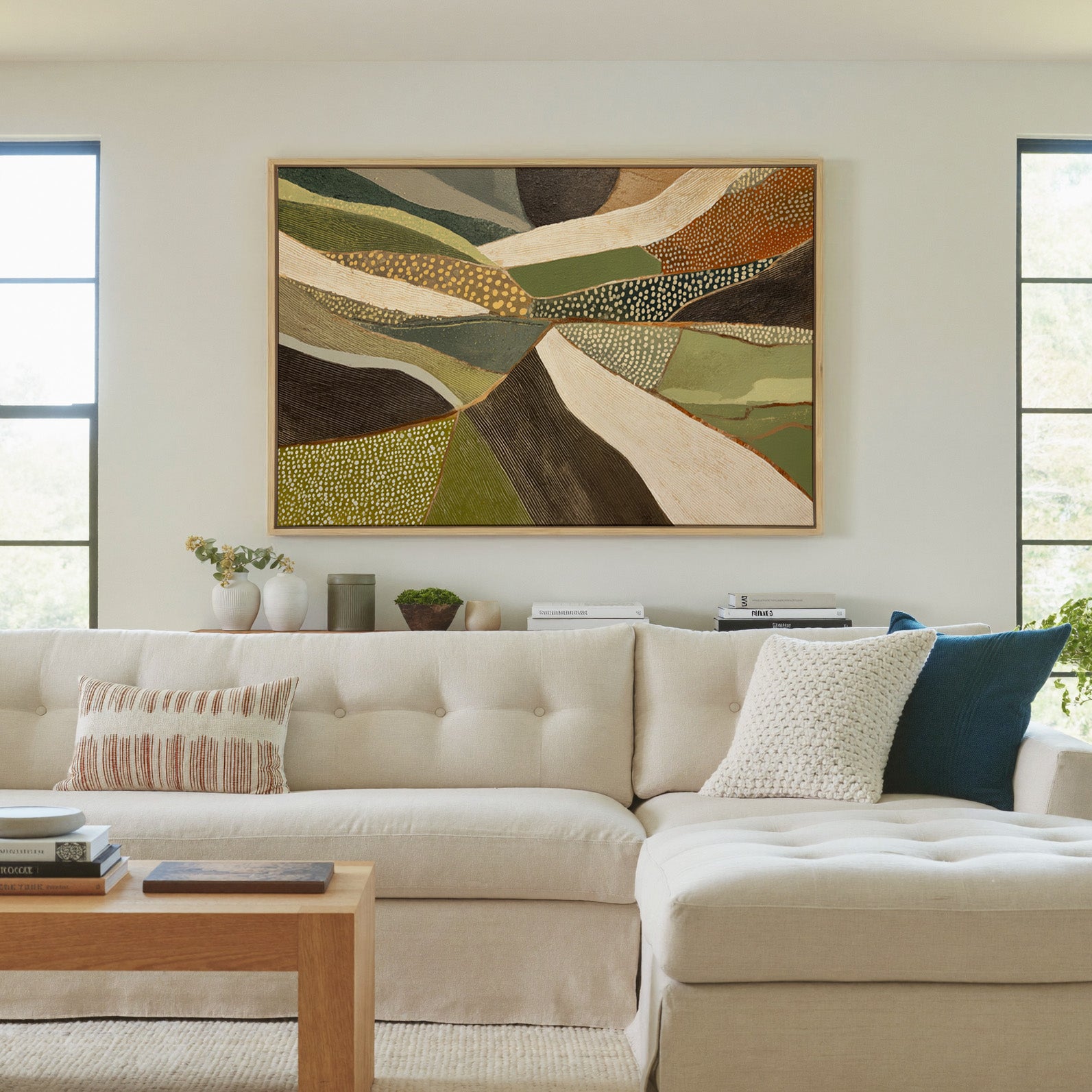 layered olive, cream, and brown abstract with canvas wall art in a natural wood frame in a living room