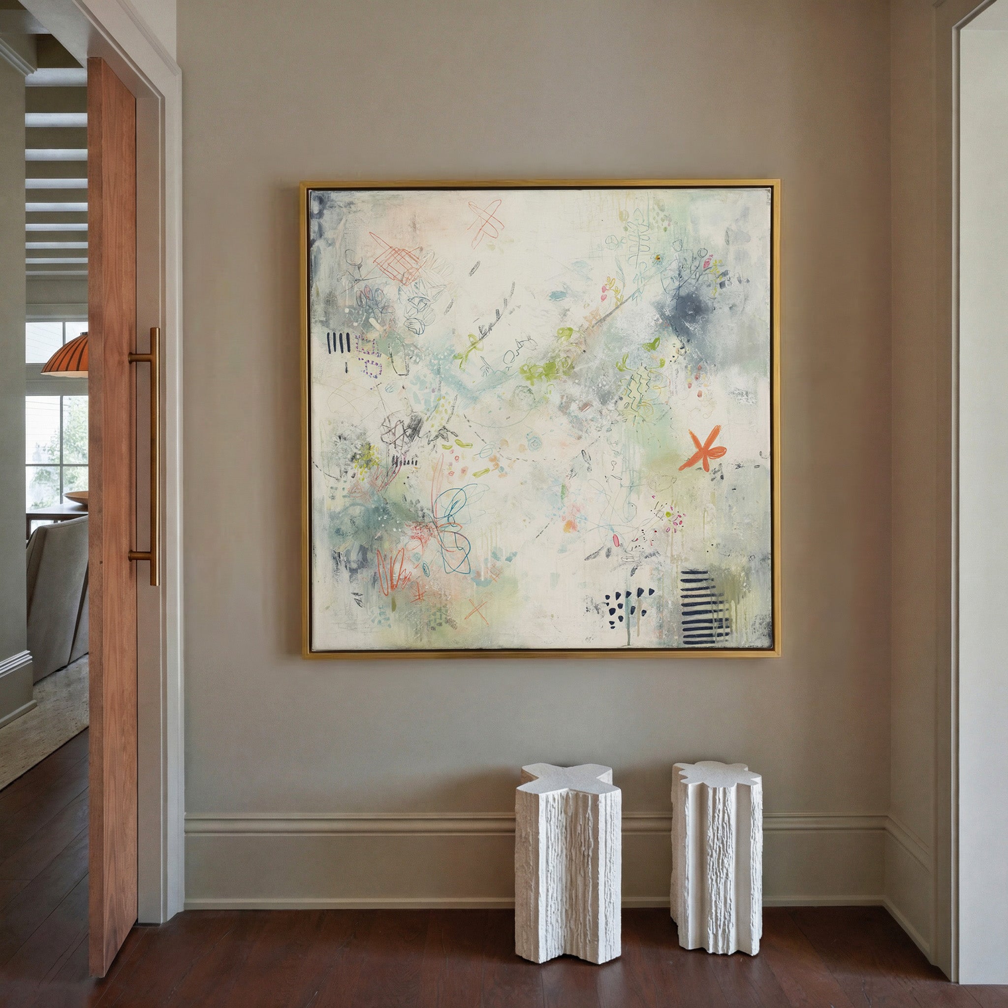 airy cream abstract with pastel doodles and canvas wall art in a gold frame in a styled room setting