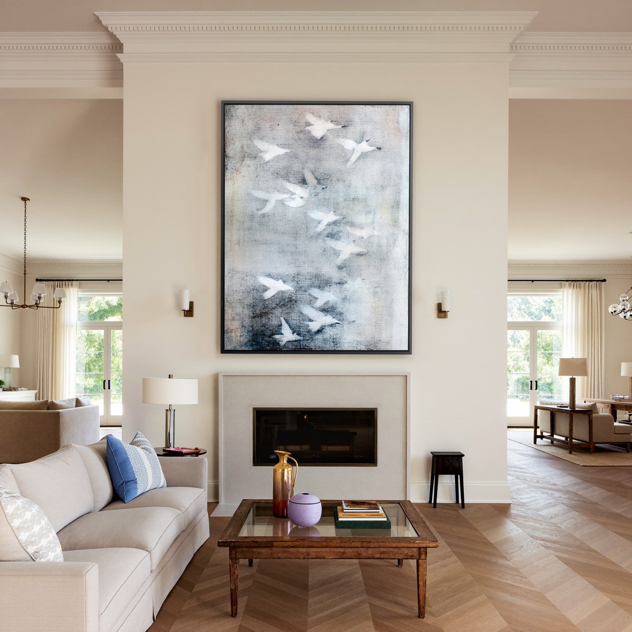 white birds over a misty gray ground canvas wall art in a black frame above a mantel