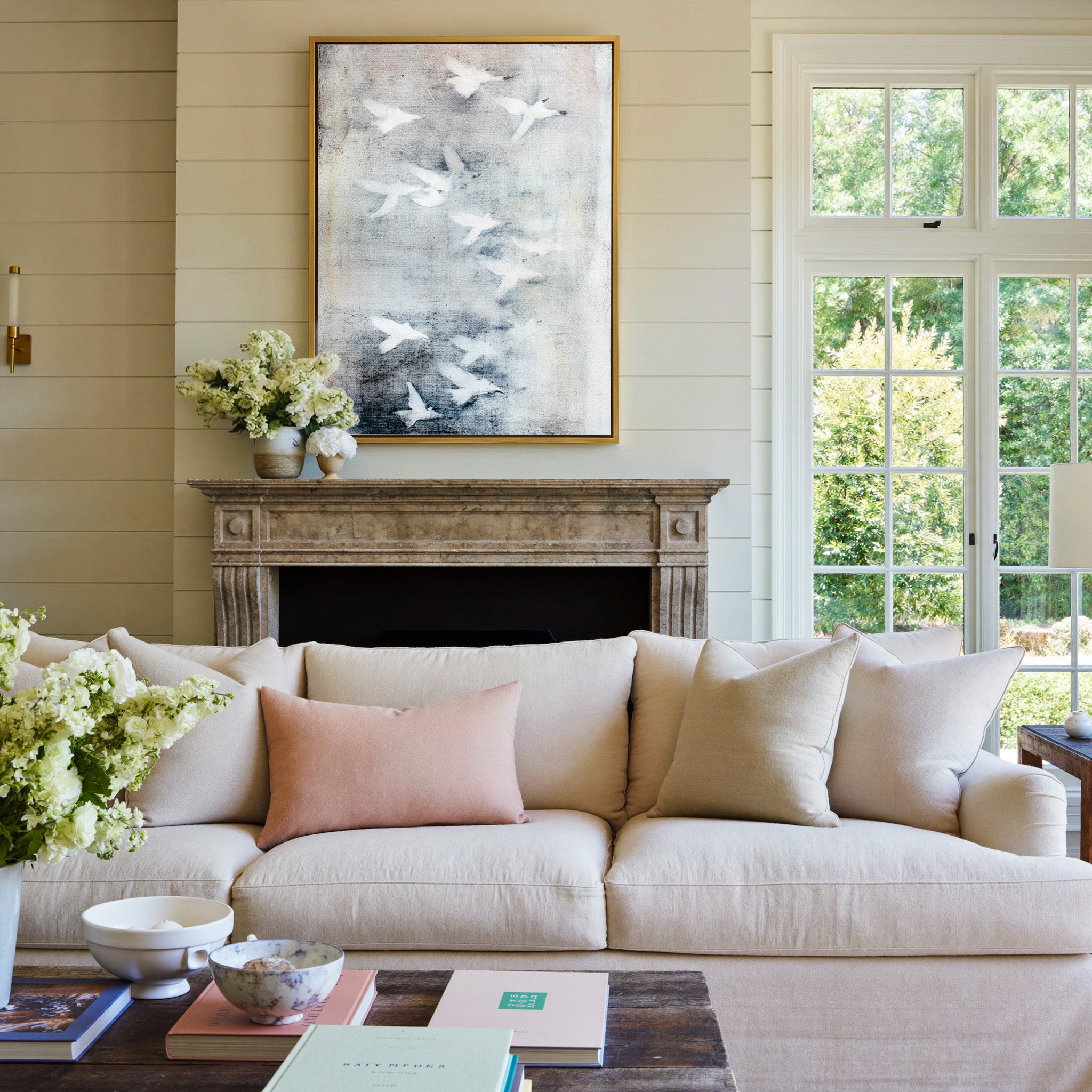 white birds over a misty gray ground canvas wall art in a gold frame above a mantel