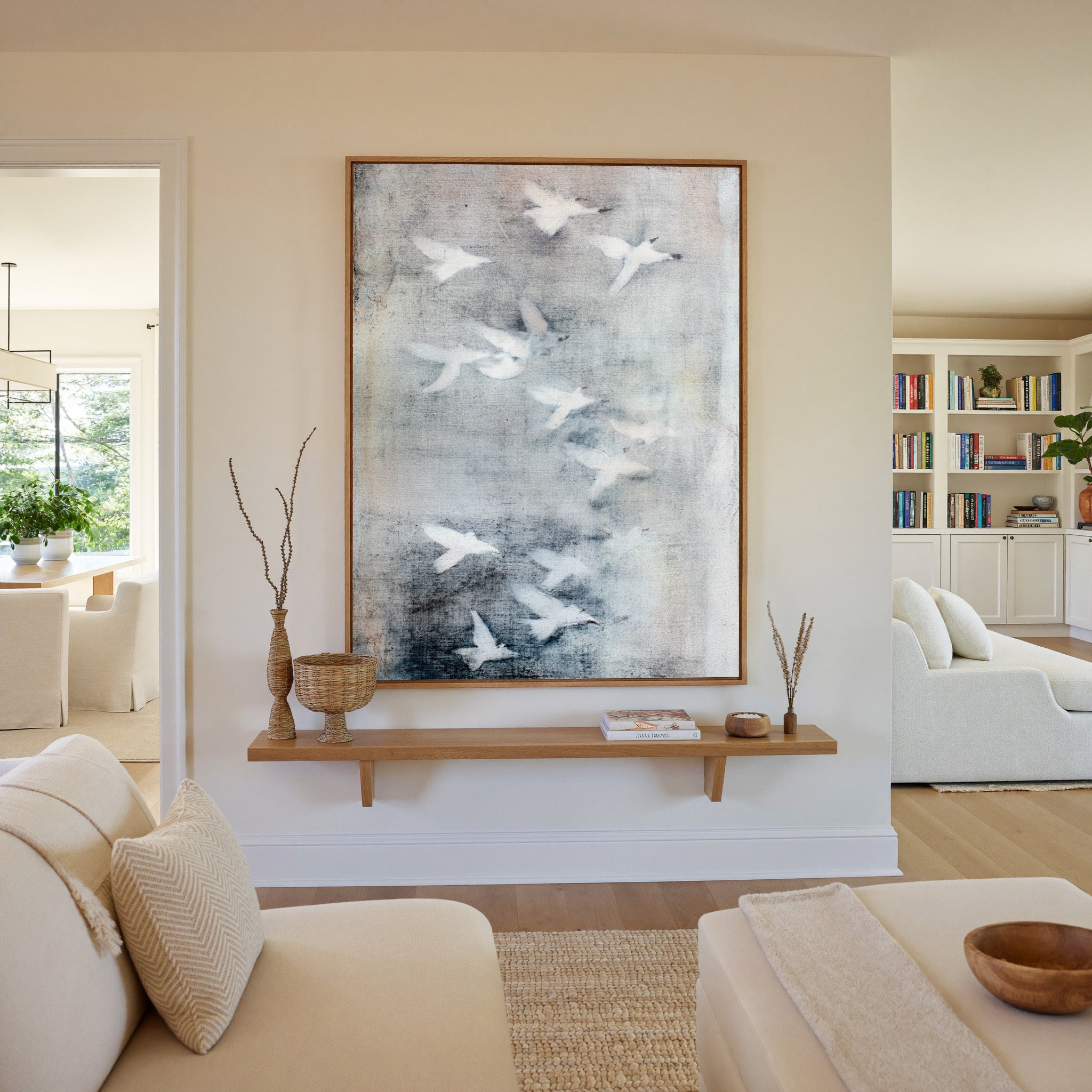 white birds over a misty gray ground canvas wall art in an oak frame in a living room