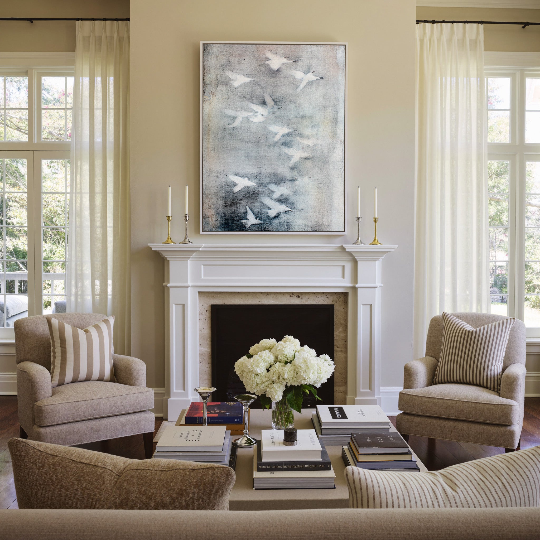 white birds over a misty gray ground canvas wall art in a white frame above a mantel