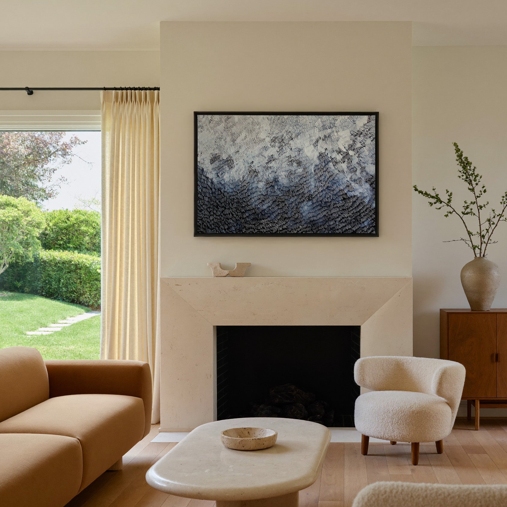black and white abstract with dense curved canvas wall art in a black frame above a mantel