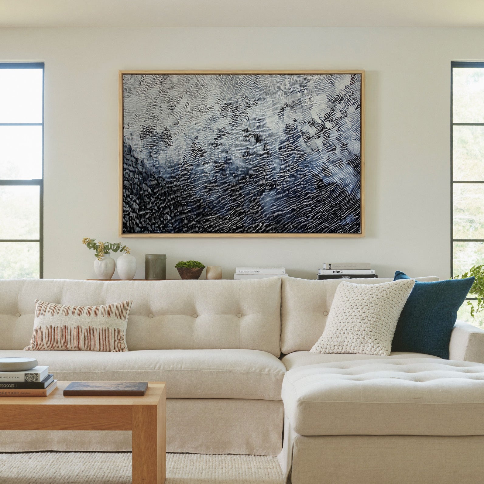 black and white abstract with dense curved canvas wall art in a natural wood frame in a living room