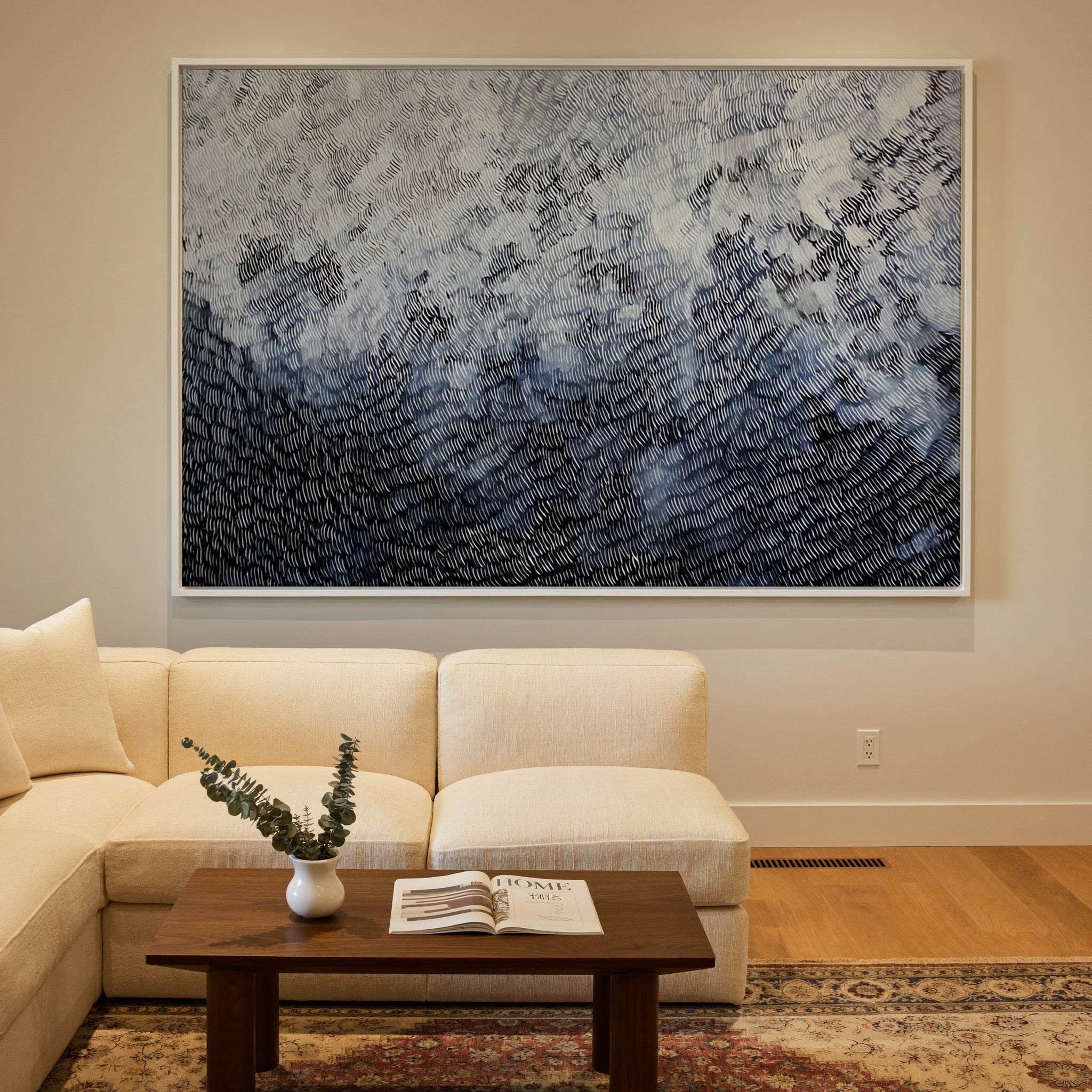 black and white abstract with dense curved canvas wall art in a white frame in a styled room setting