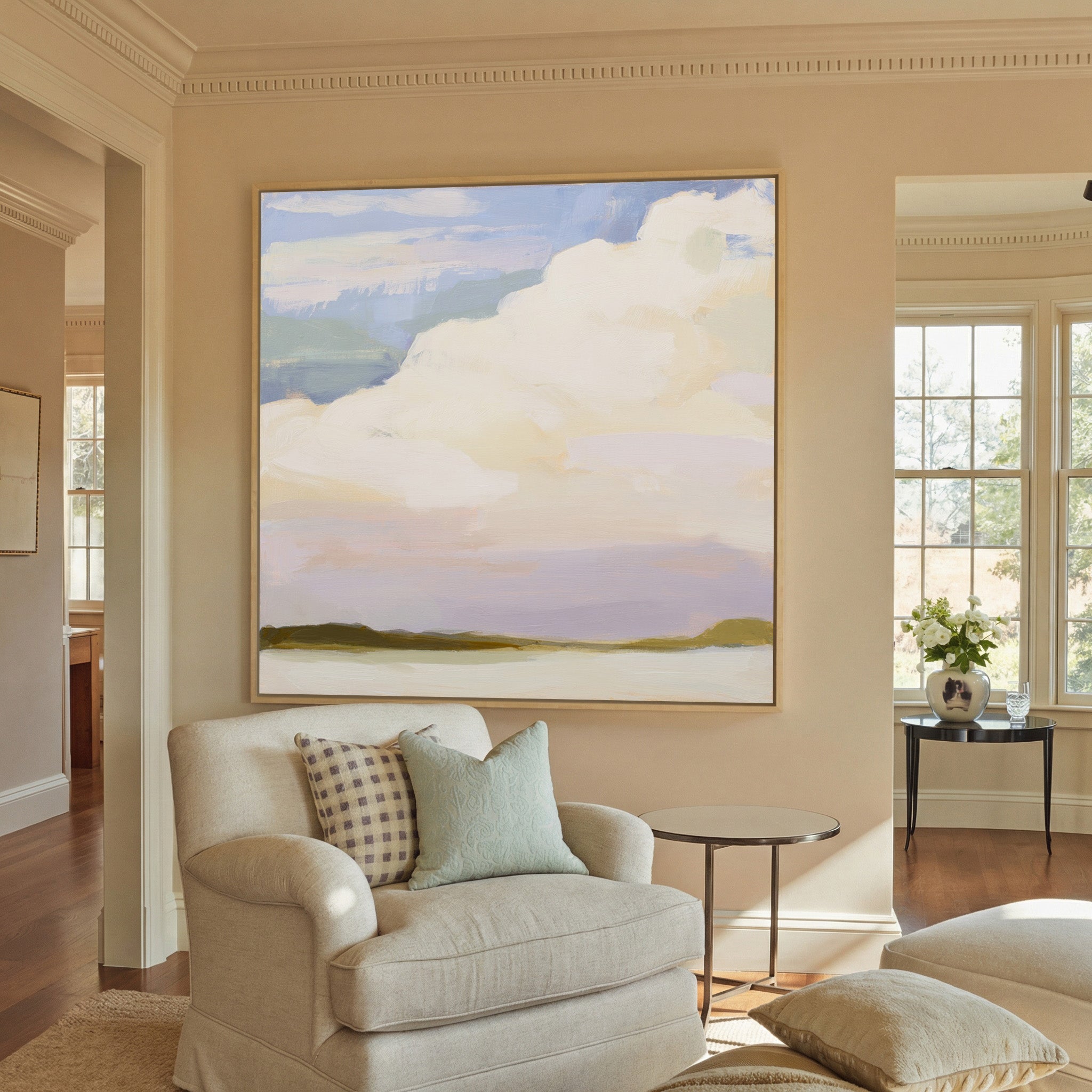 soft white clouds over pale blue and lavender canvas wall art in a natural wood frame in a styled room setting