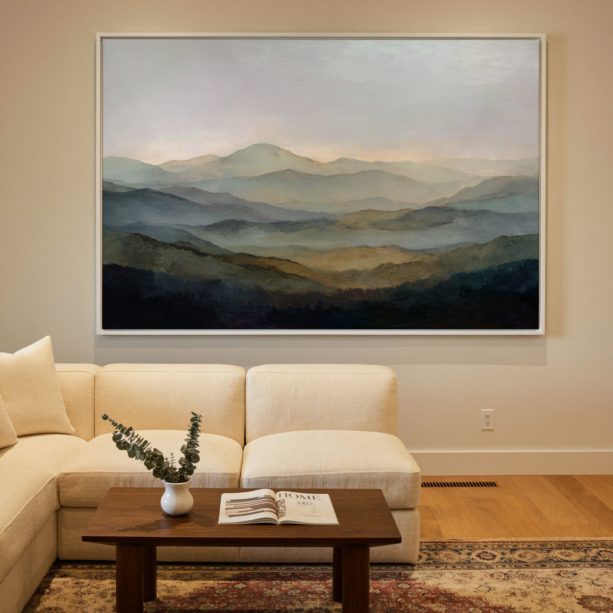 misty layered mountain landscape canvas wall art in a white frame in a styled room setting
