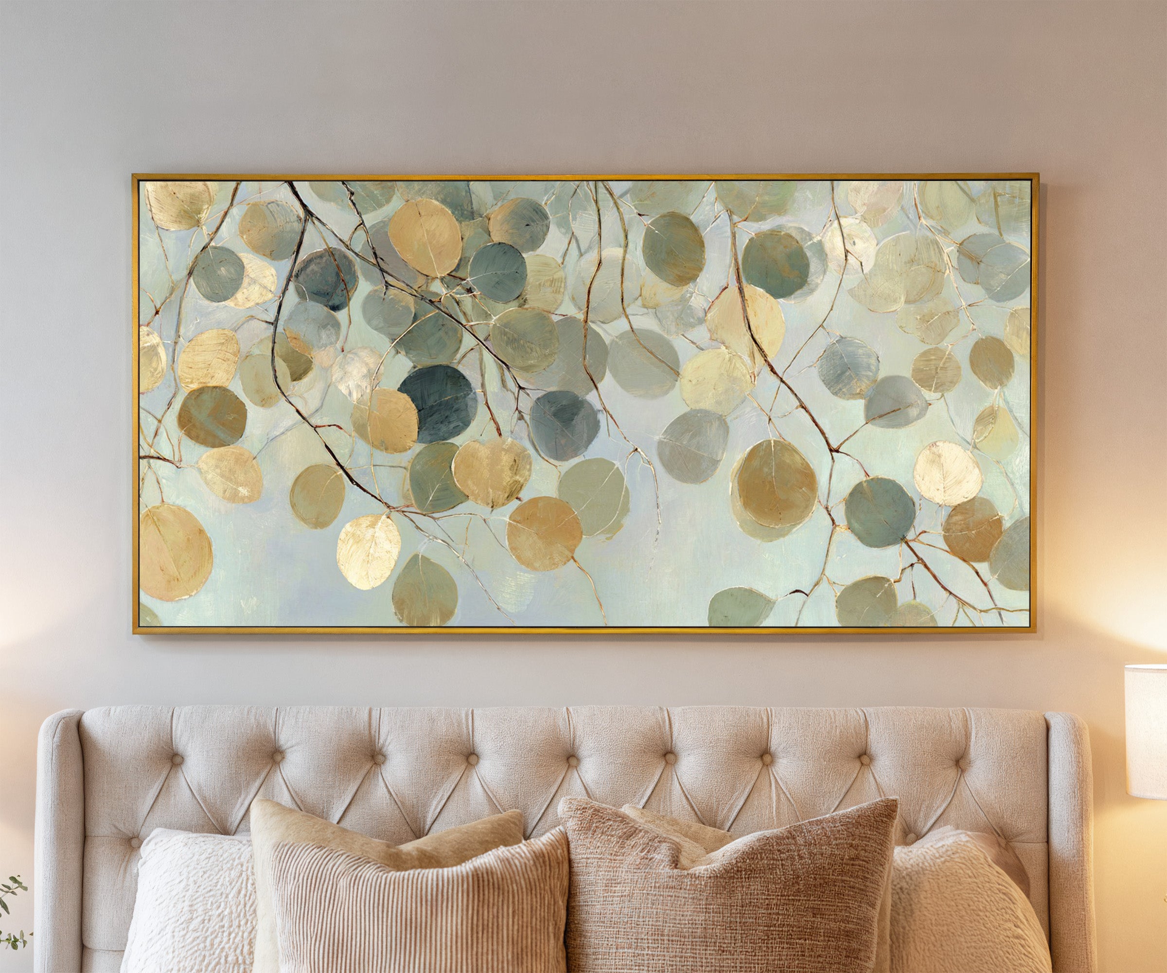 pale round leaves on branching stems canvas wall art in a gold frame above a bed