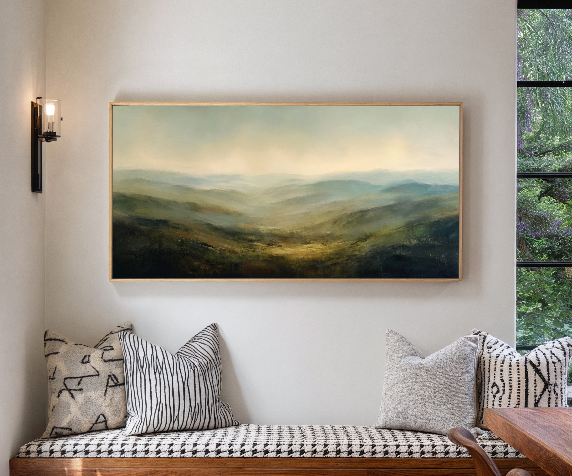 soft blue green ridgelines with a bright canvas wall art in a natural wood frame in a living room