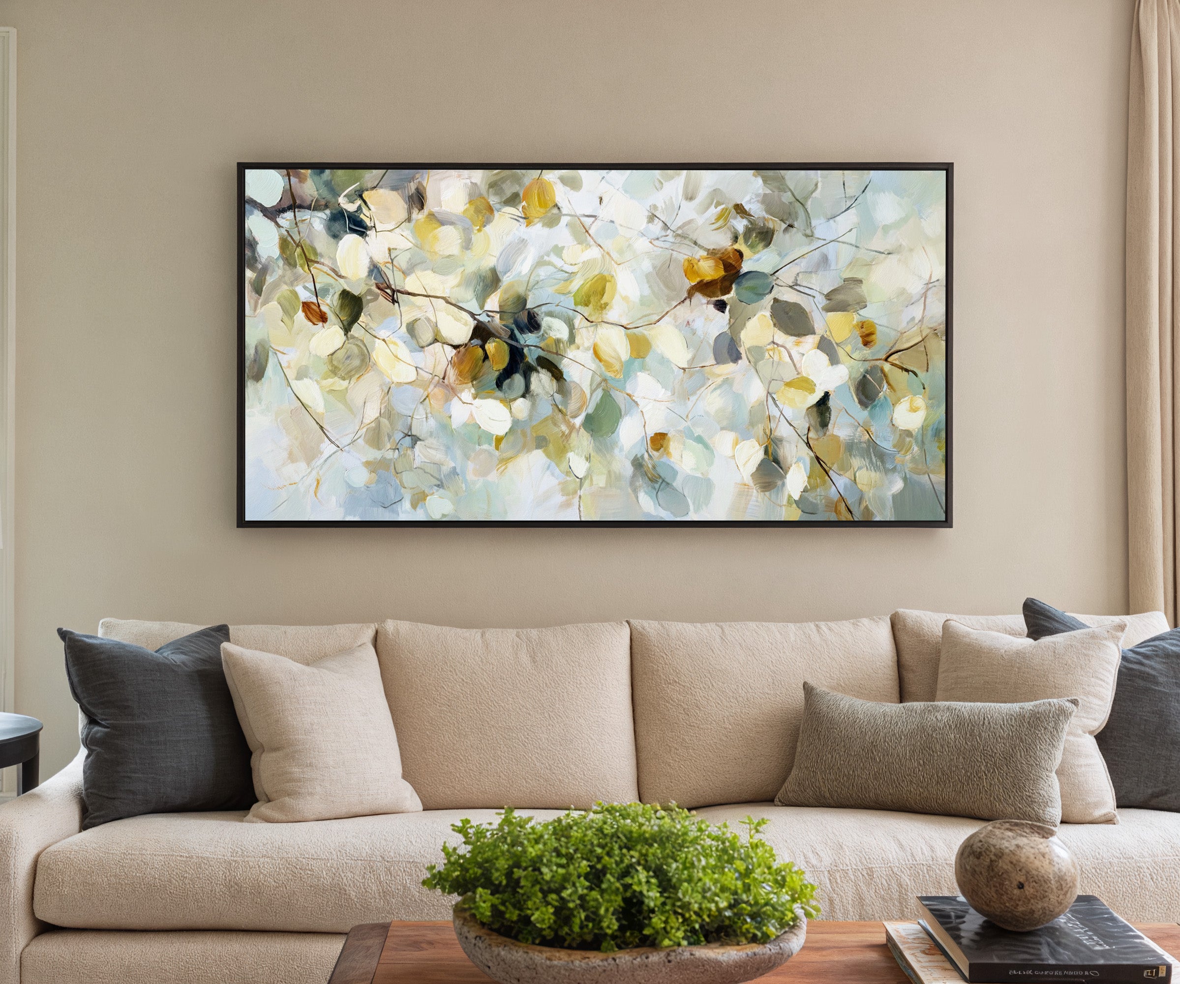 soft blue, cream, and gold leaf branch canvas wall art in a black frame in a styled room setting