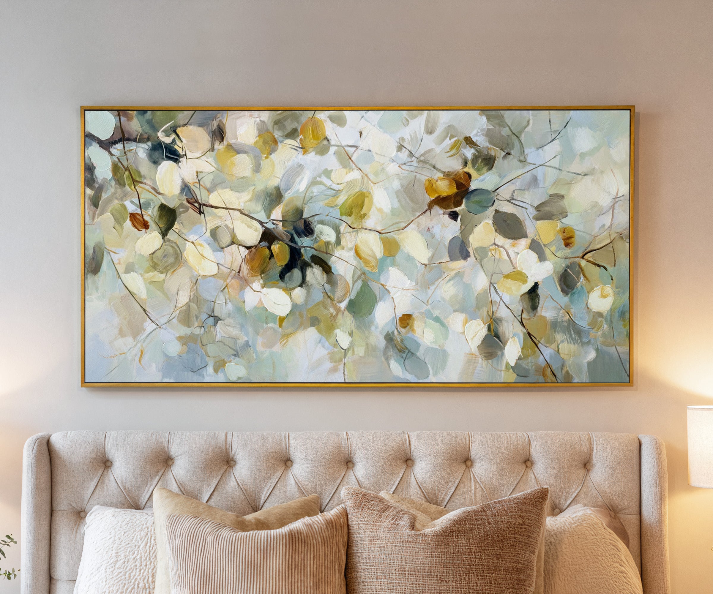 soft blue, cream, and gold leaf branch canvas wall art in a gold frame above a bed