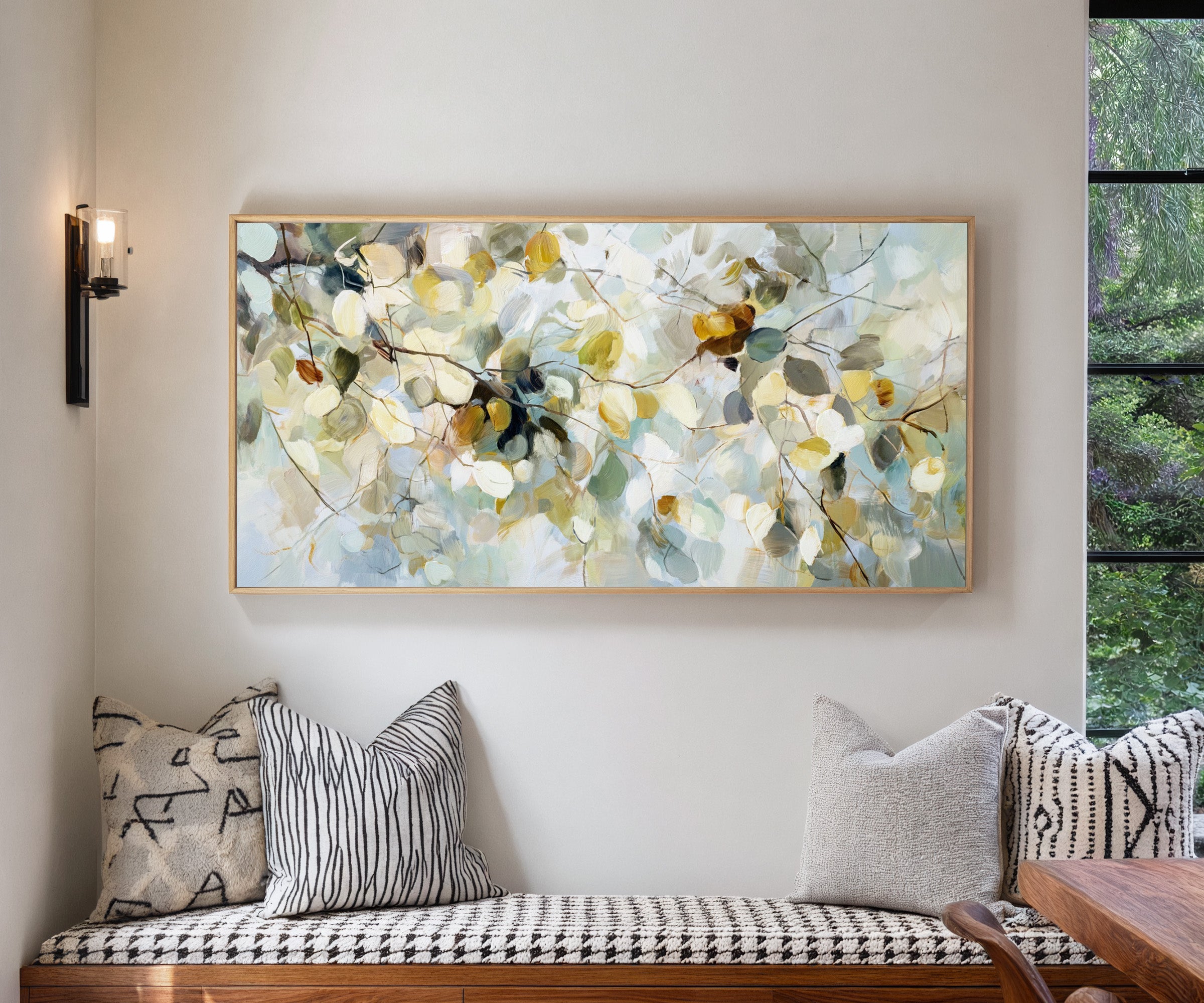 soft blue, cream, and gold leaf branch canvas wall art in a natural wood frame in a living room