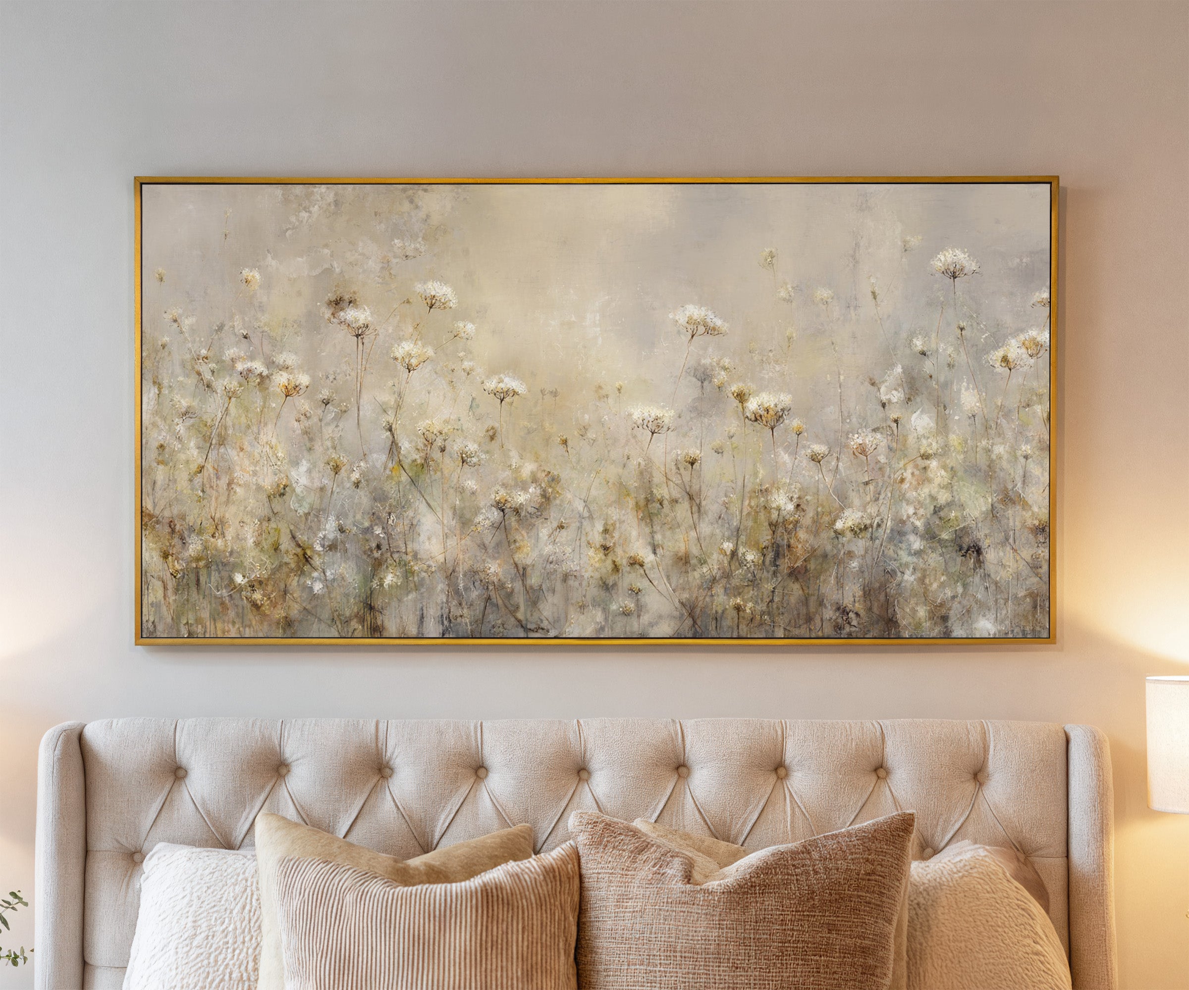 pale wildflower meadow with tall stems and soft canvas wall art in a gold frame above a bed