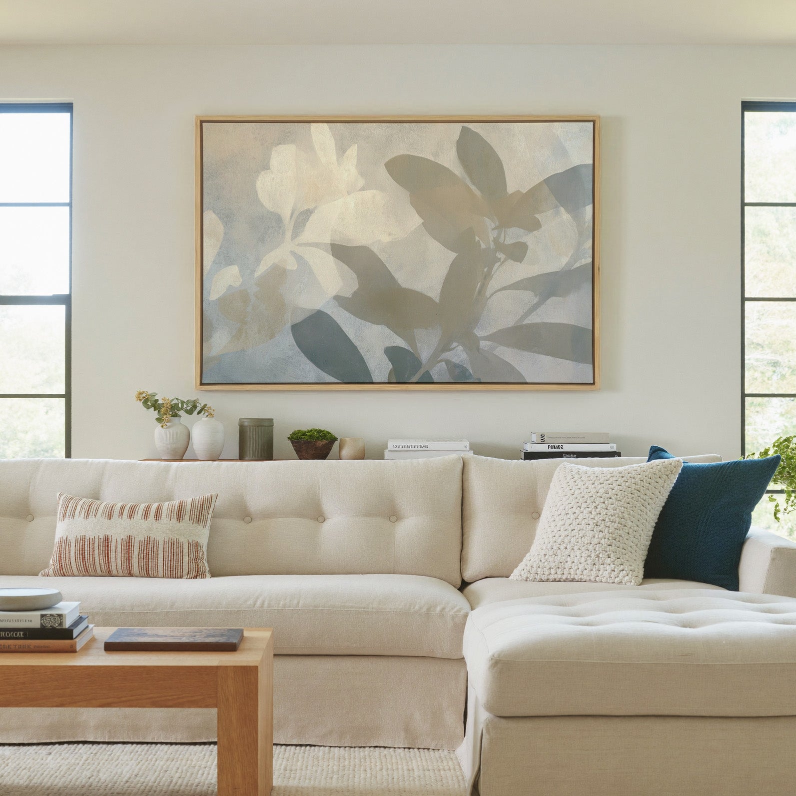 soft beige and gray leaf branch abstract canvas wall art in a natural wood frame in a living room