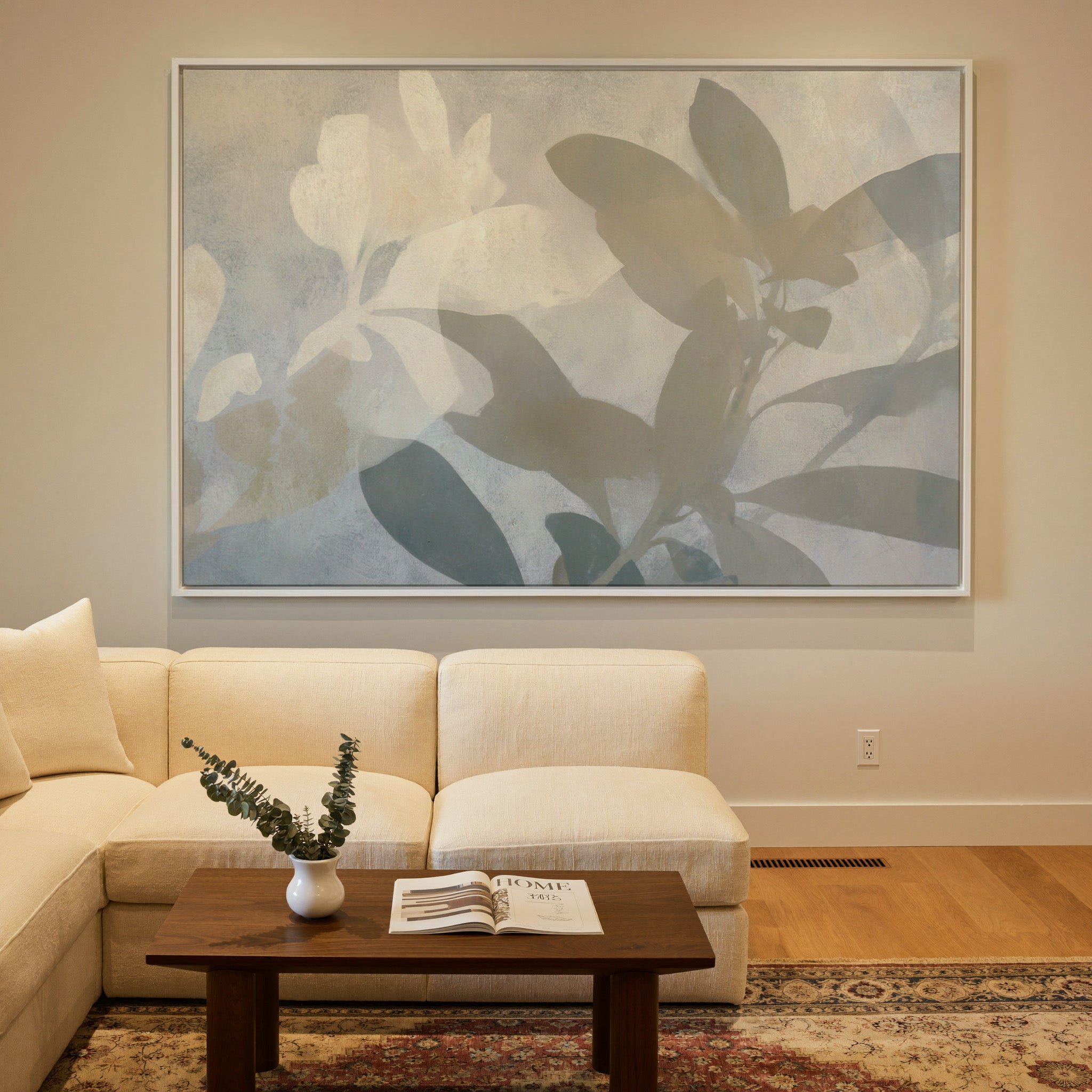 soft beige and gray leaf branch abstract canvas wall art in a white frame in a styled room setting