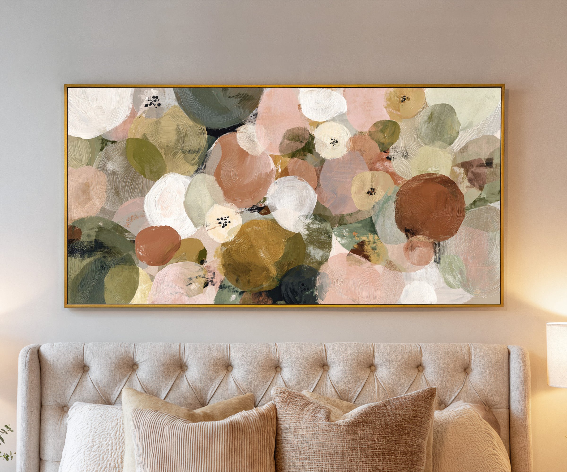 muted olive, blush, cream, and gold circles canvas wall art in a gold frame above a bed