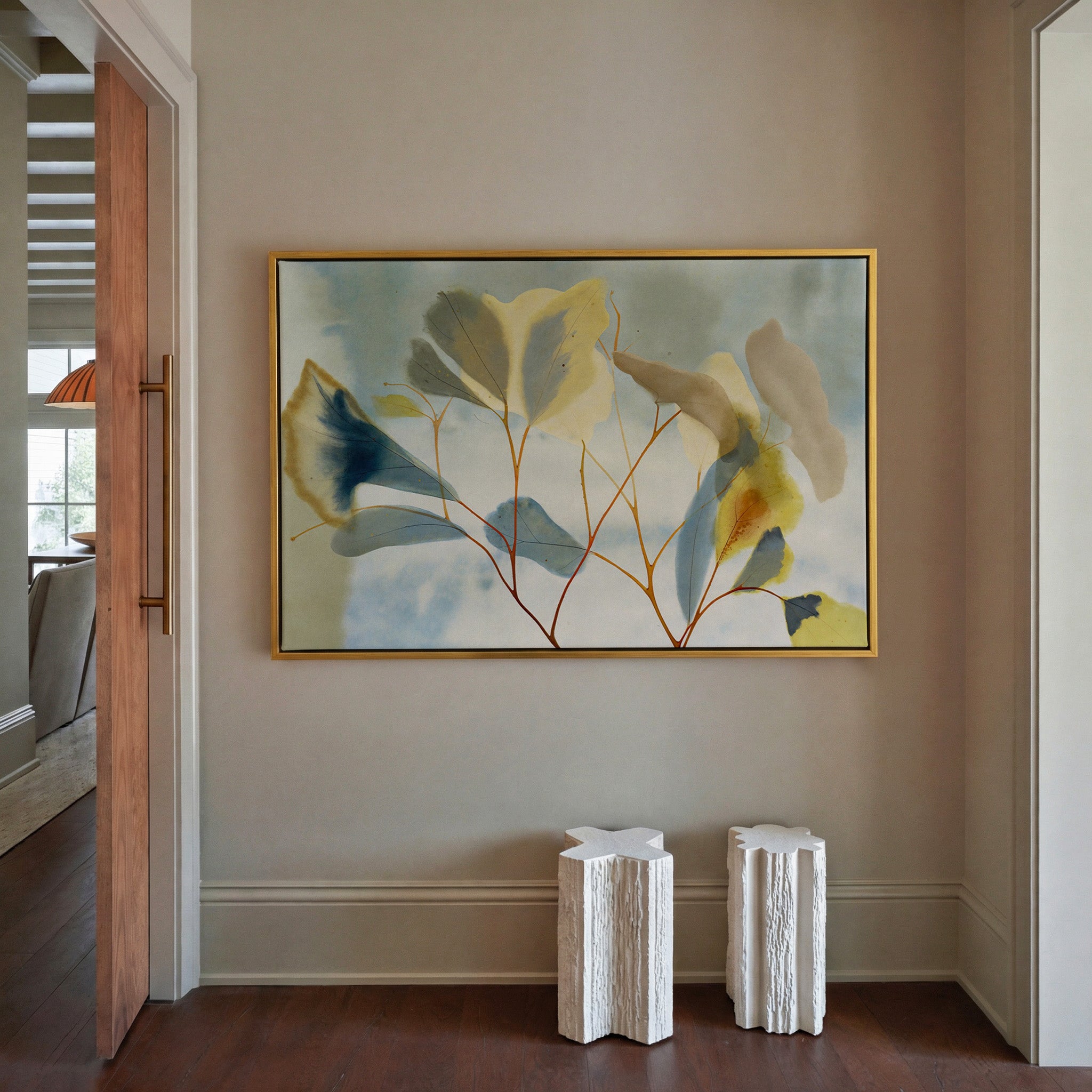 blue, cream, and yellow leaf branch canvas wall art in a gold frame in a styled room setting