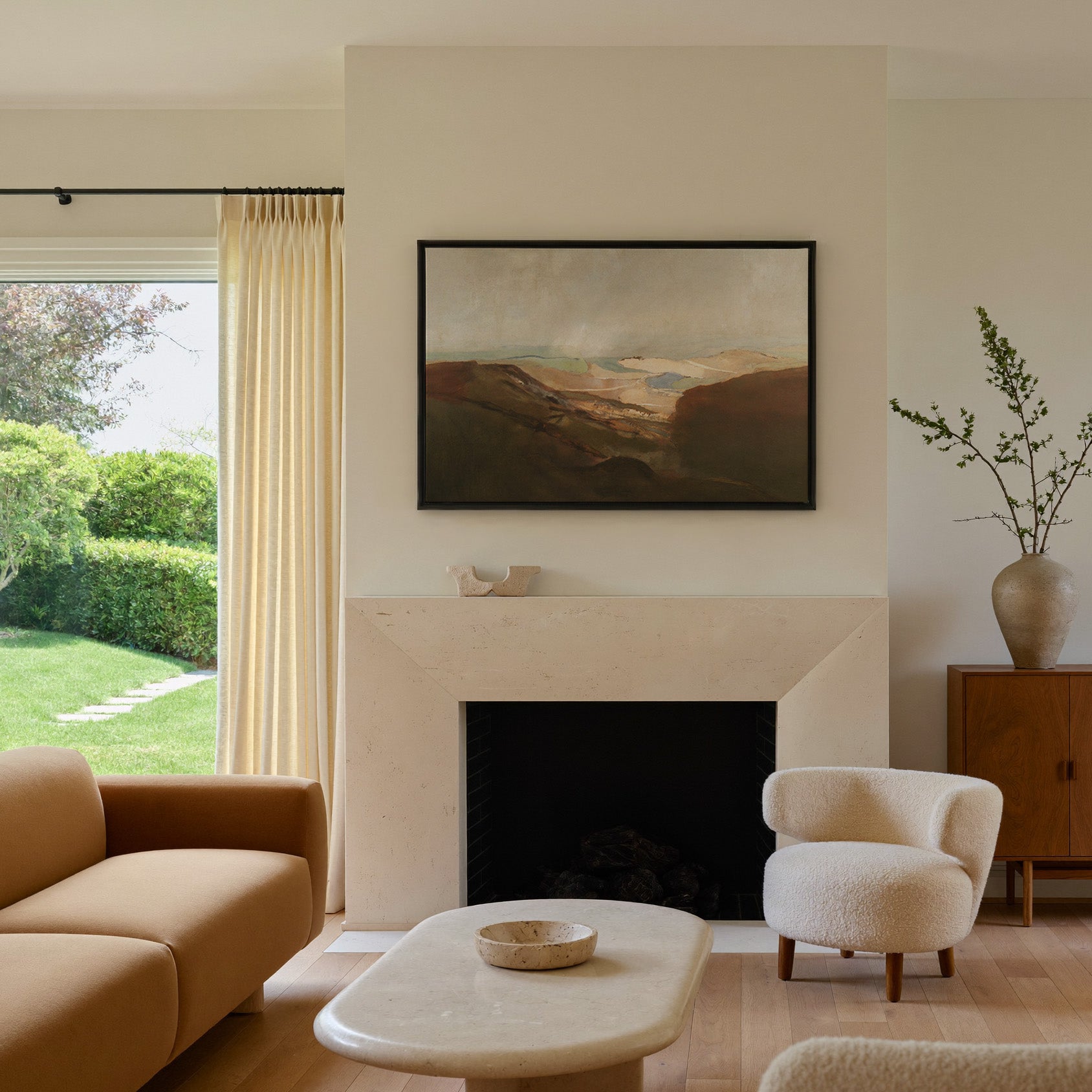 soft desert landscape with layered dunes and a canvas wall art in a black frame above a mantel