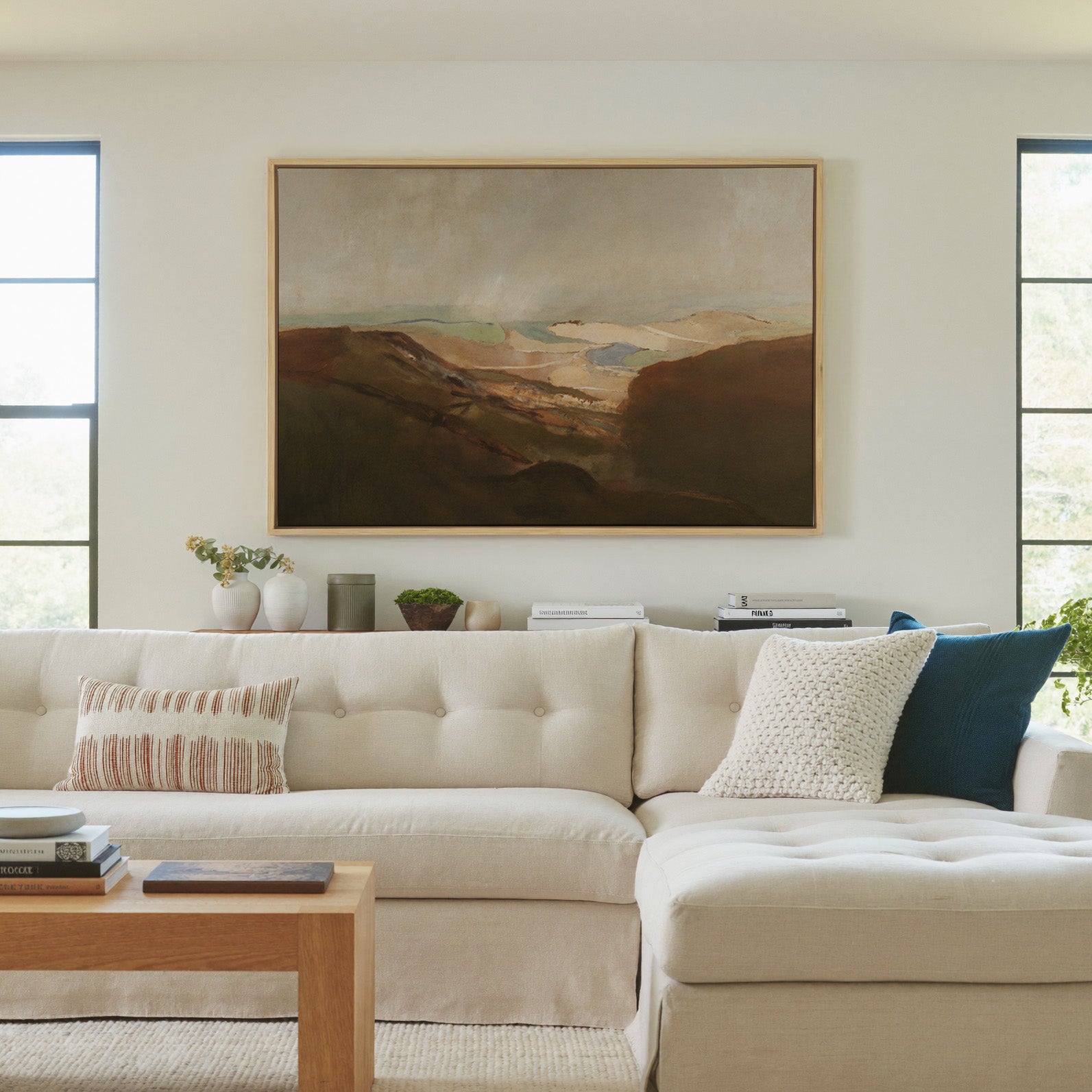soft desert landscape with layered dunes and a canvas wall art in a natural wood frame in a living room