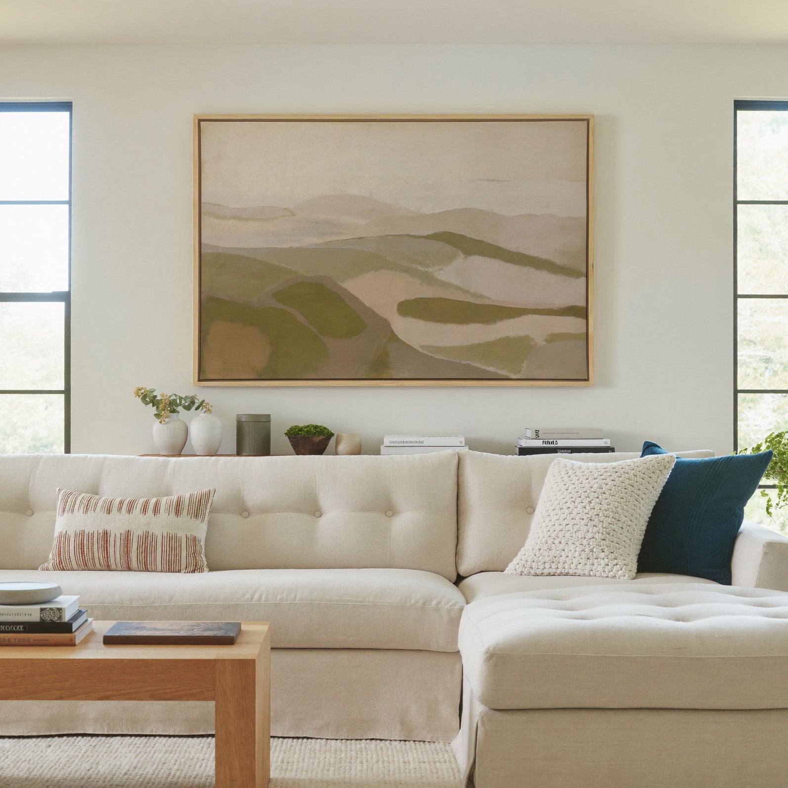 soft beige and olive abstract with layered canvas wall art in a natural wood frame in a living room