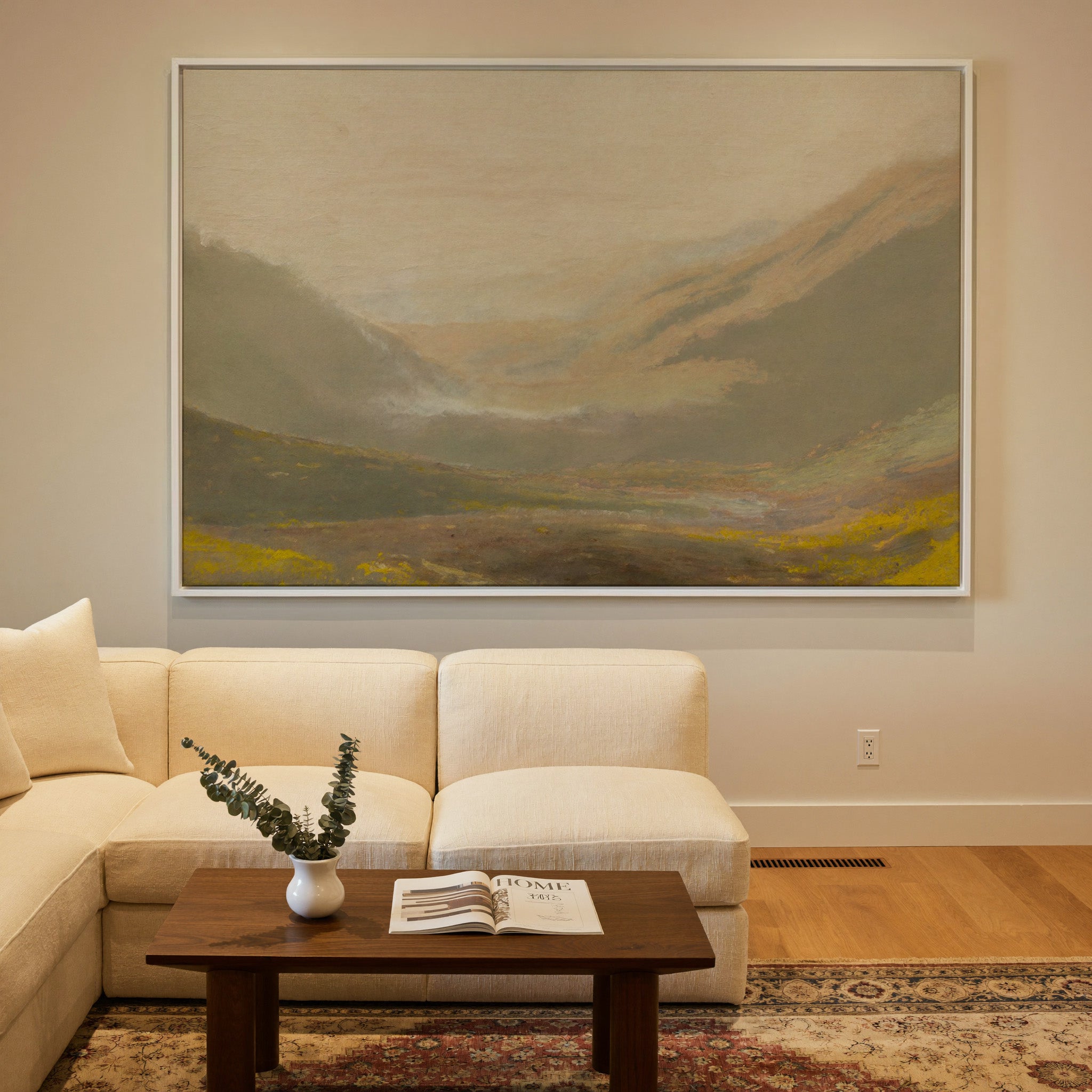 misty valley landscape with ochre hills and a canvas wall art in a white frame in a styled room setting