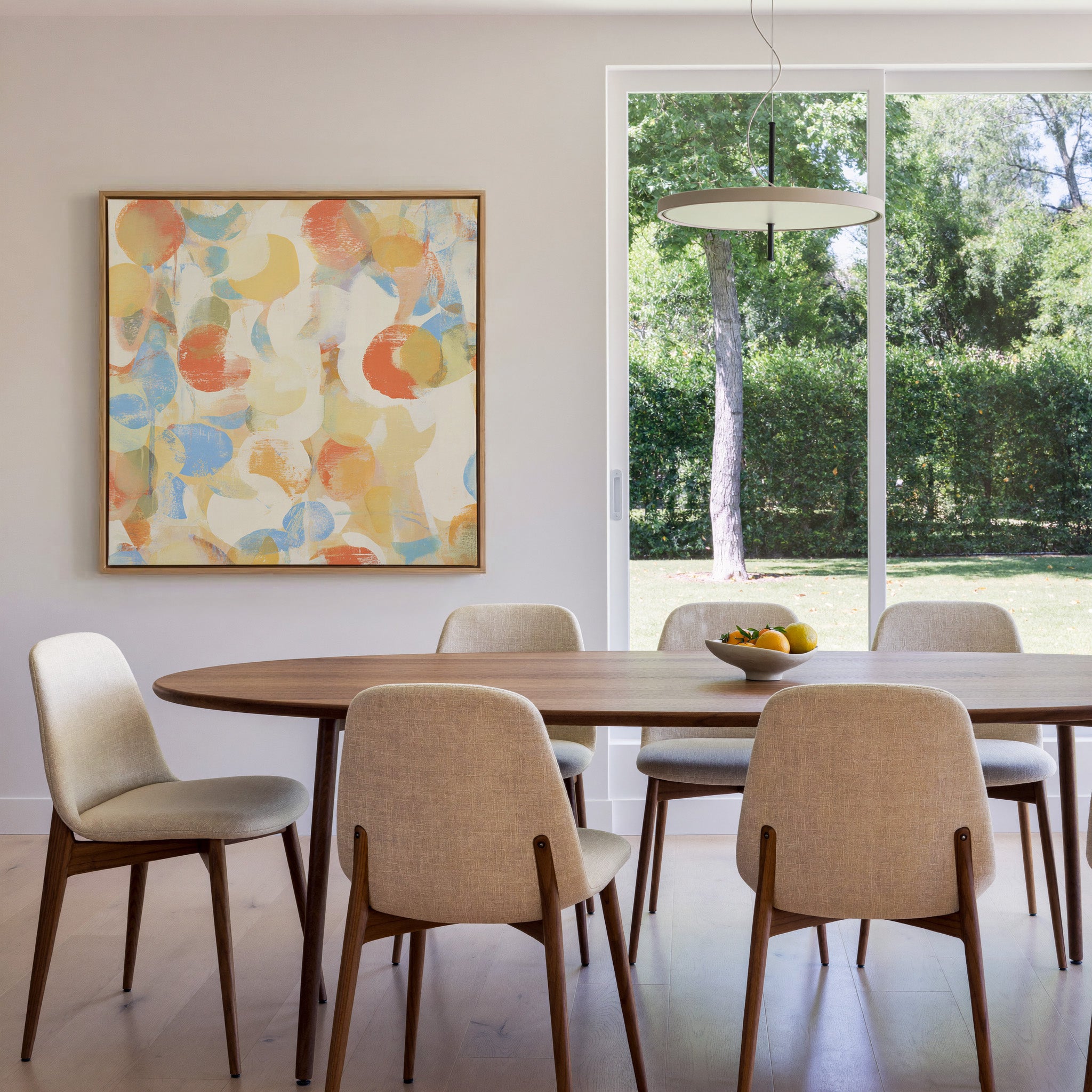 soft pastel circle abstract canvas wall art in an oak frame in a dining room