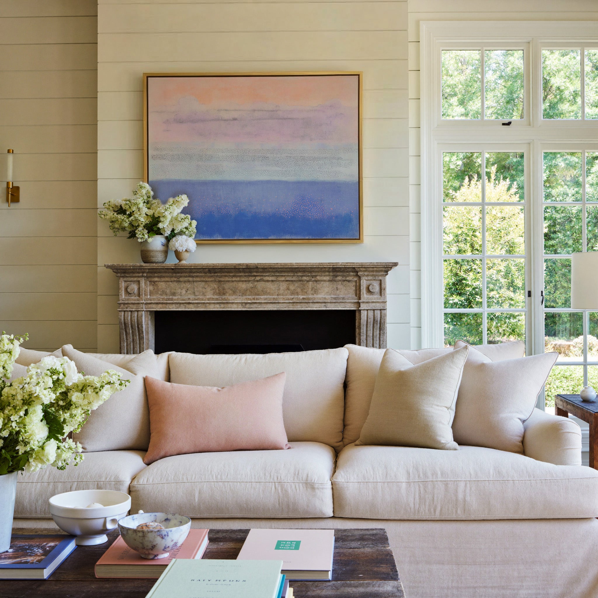 soft peach, lavender, and blue abstract canvas wall art in a gold frame above a mantel