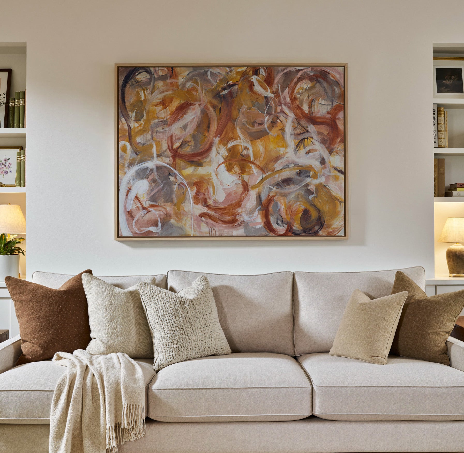 warm rust, gold, cream, and gray canvas wall art in a natural wood frame in a styled room setting
