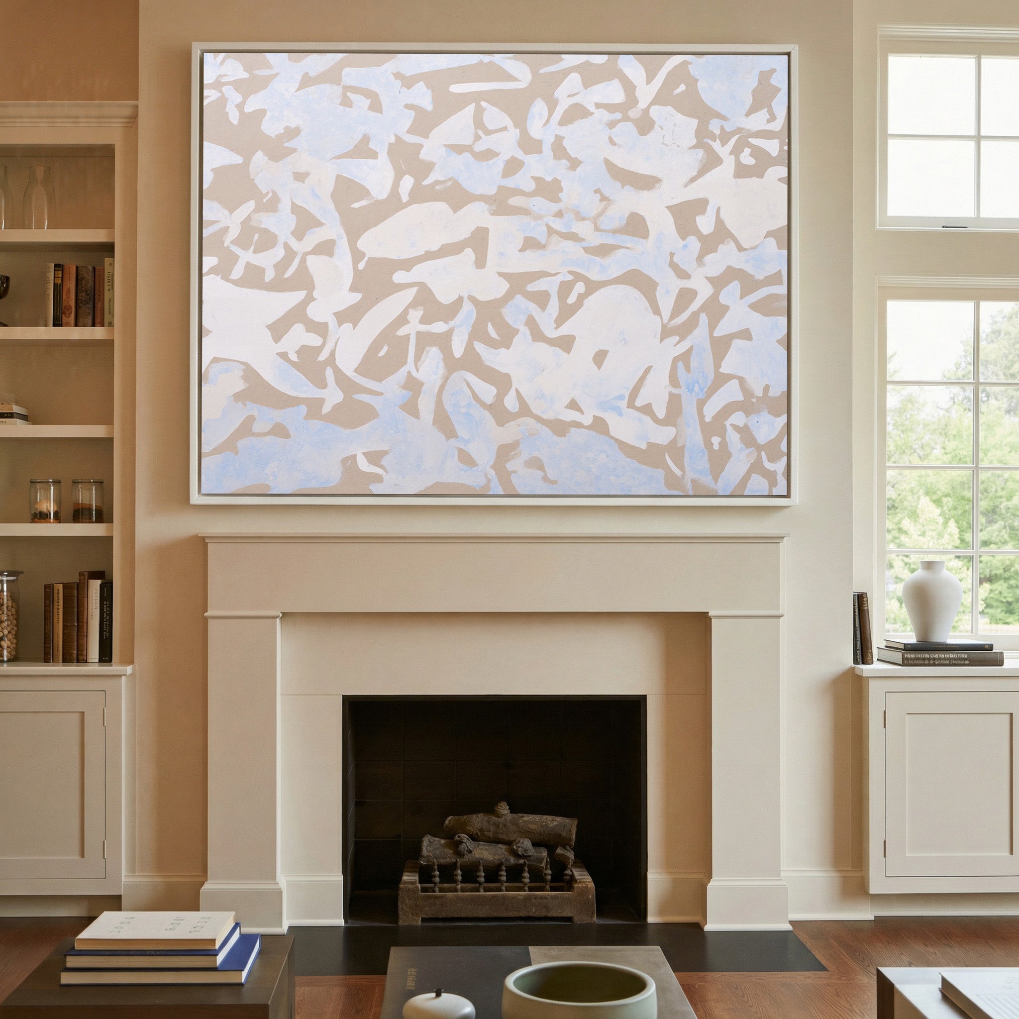 soft beige and pale blue abstract canvas wall art in a white frame above a mantel