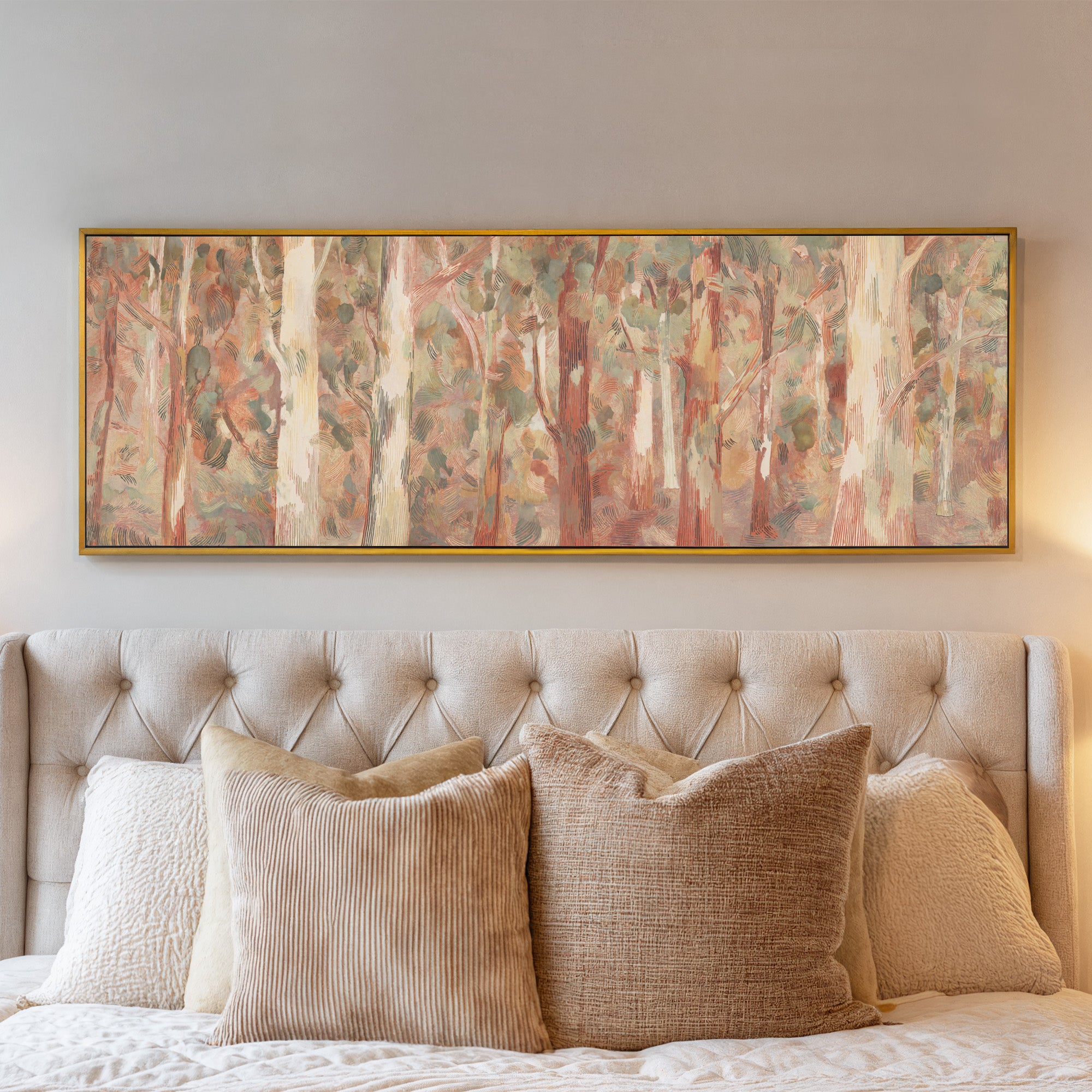 soft eucalyptus forest with pale trunks and canvas wall art in a gold frame above a bed