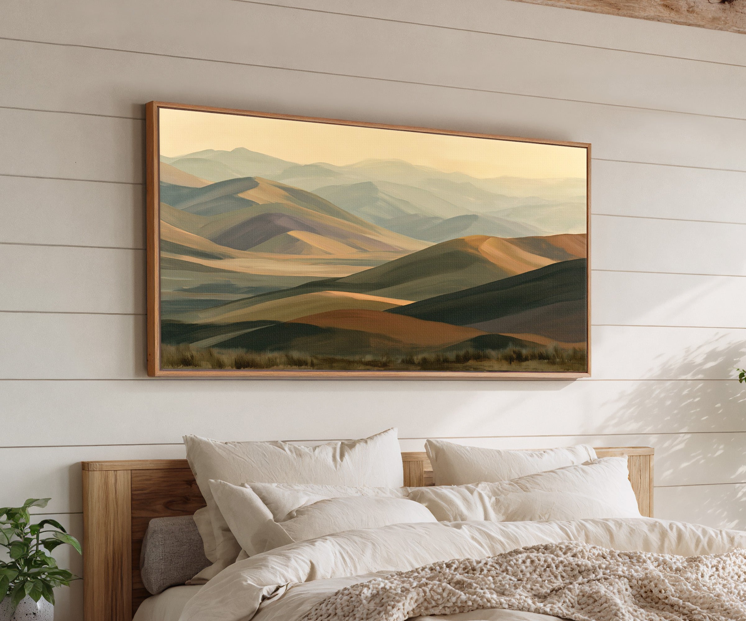 layered mountain ridges in muted gold and sage canvas wall art in an oak frame above a bed