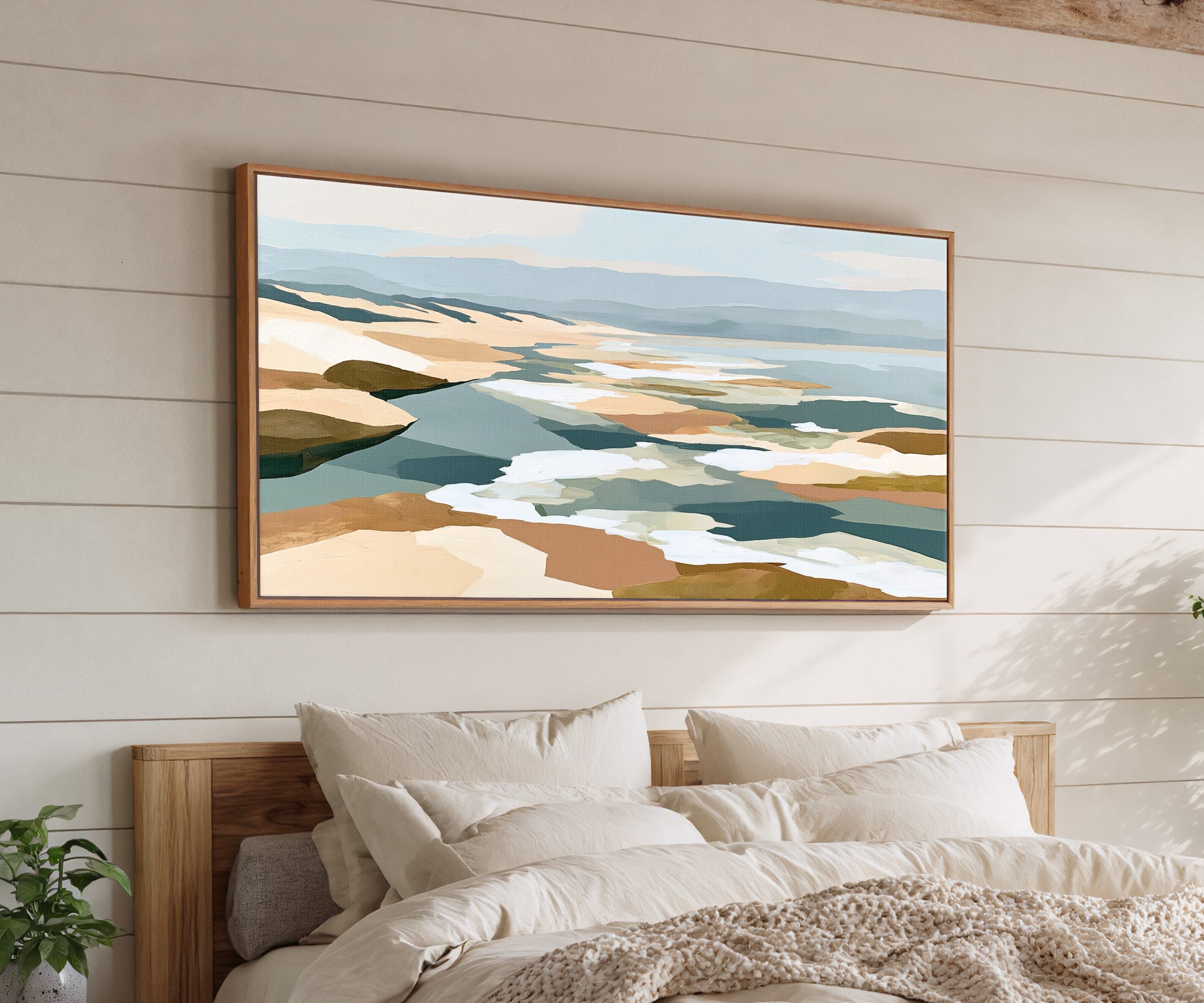 layered sandbars and blue water abstract canvas wall art in an oak frame above a bed