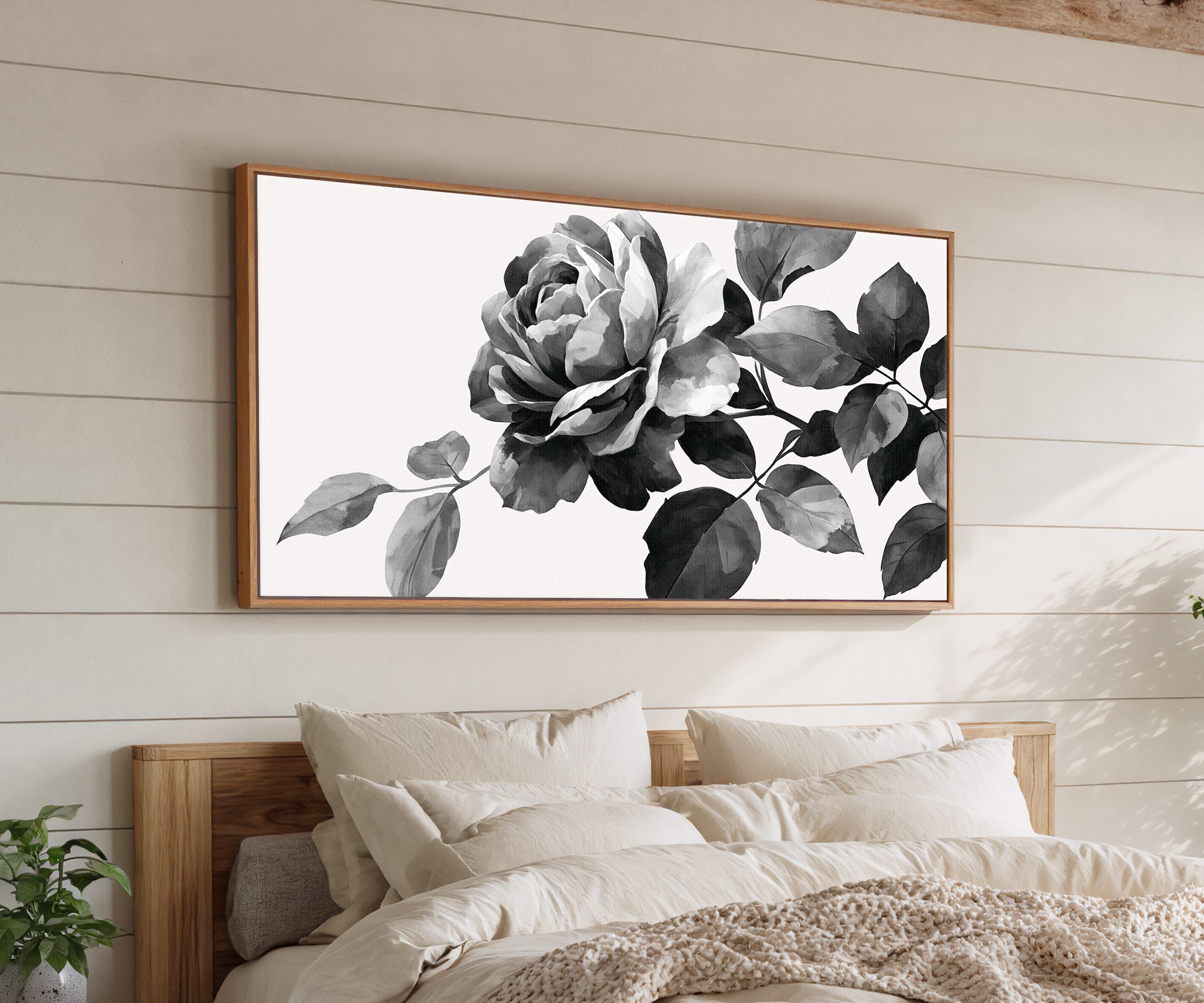 black and white floral branch canvas wall art in an oak frame above a bed