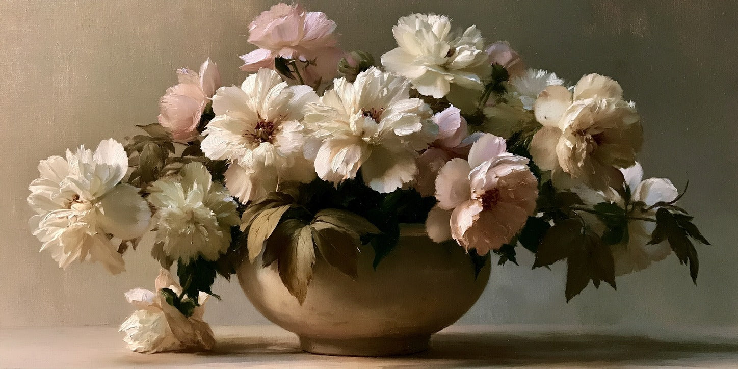 Cream and pale blush flowers spilling from a rounded bowl against a muted background