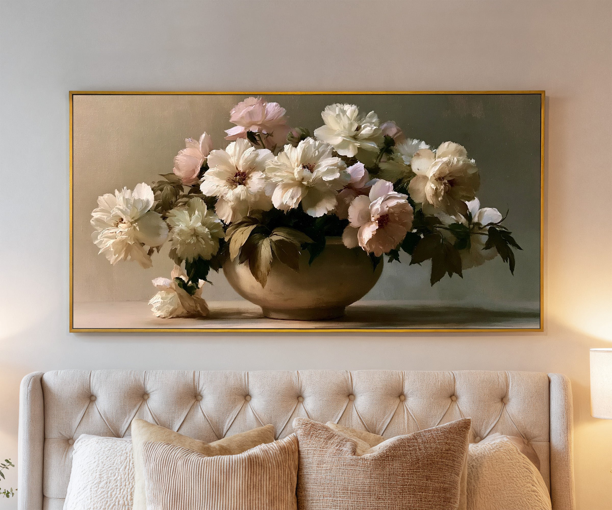 cream and pale blush floral still life canvas wall art in a gold frame above a bed