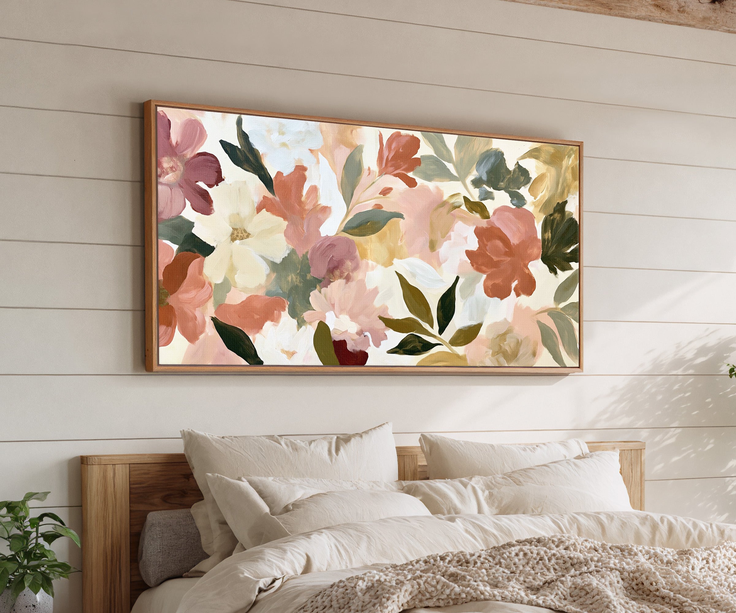 soft blush, cream, and terracotta floral forms canvas wall art in an oak frame above a bed