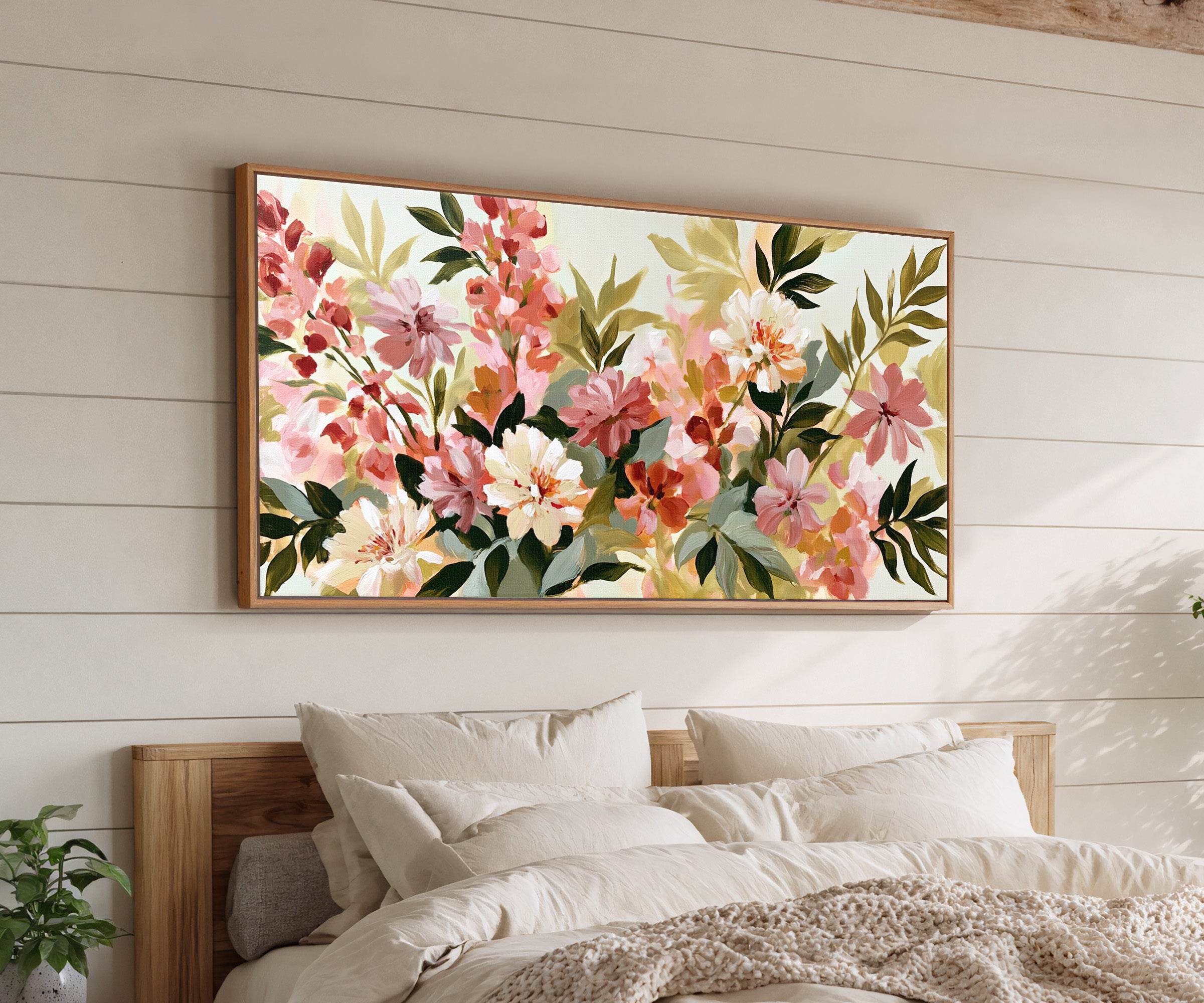 soft pink, cream, and olive floral forms canvas wall art in an oak frame above a bed