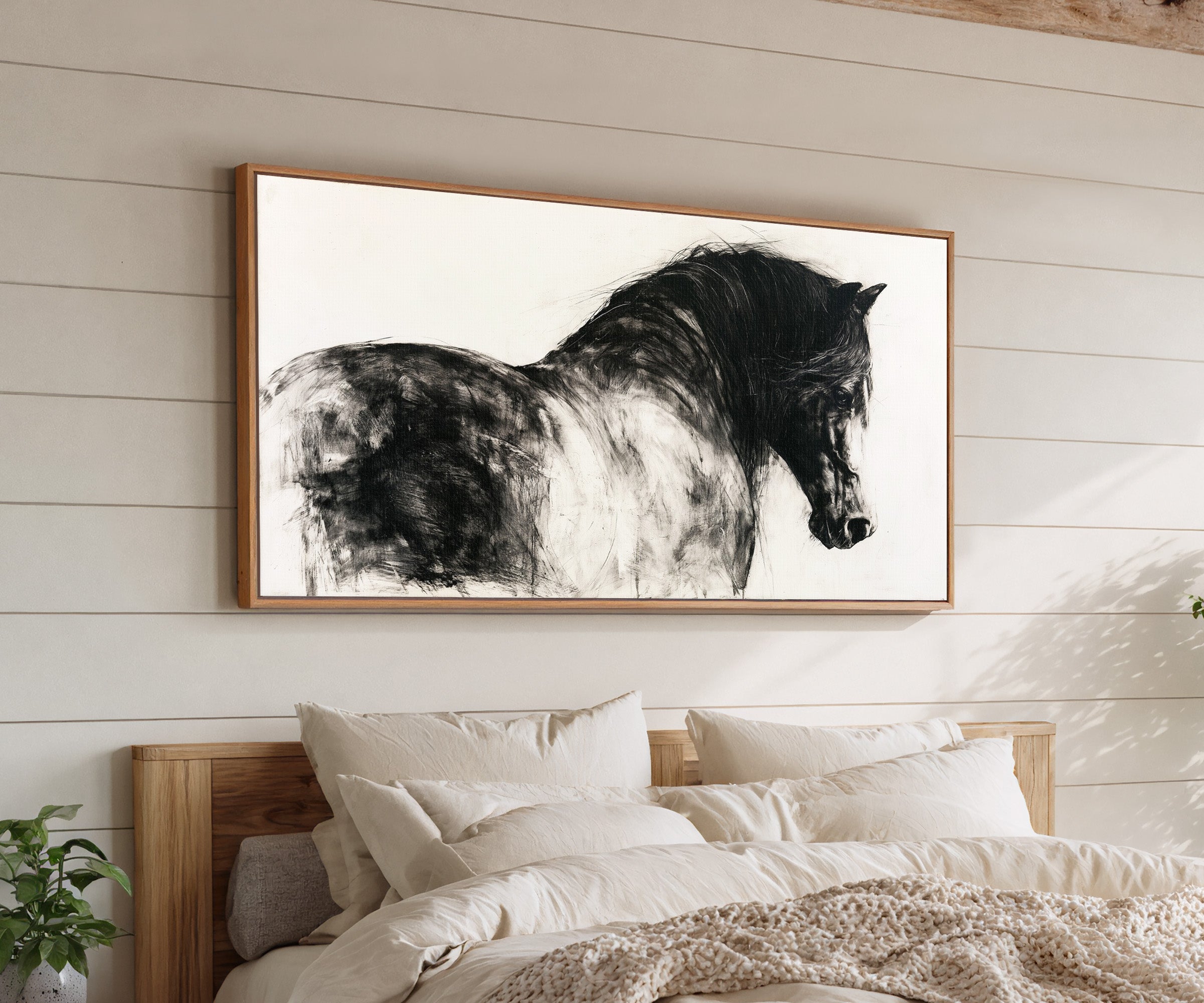 black and white close cropped horse portrait canvas wall art in an oak frame above a bed