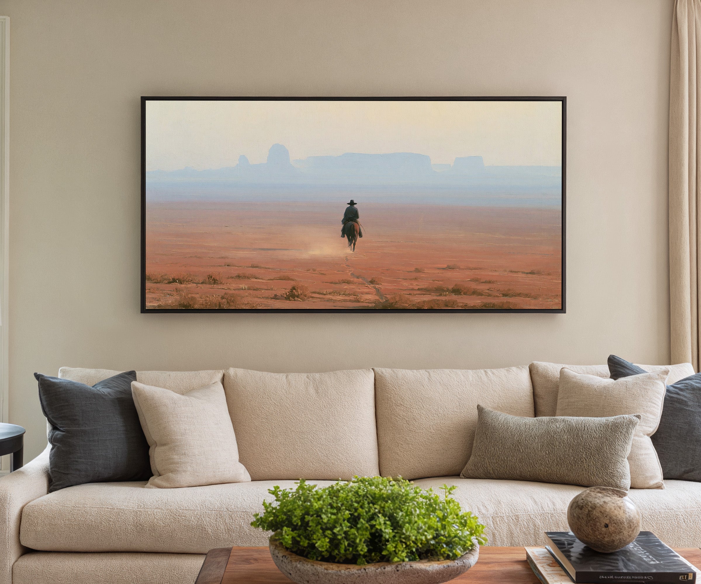 lone rider across a red desert plain with pale canvas wall art in a black frame in a styled room setting