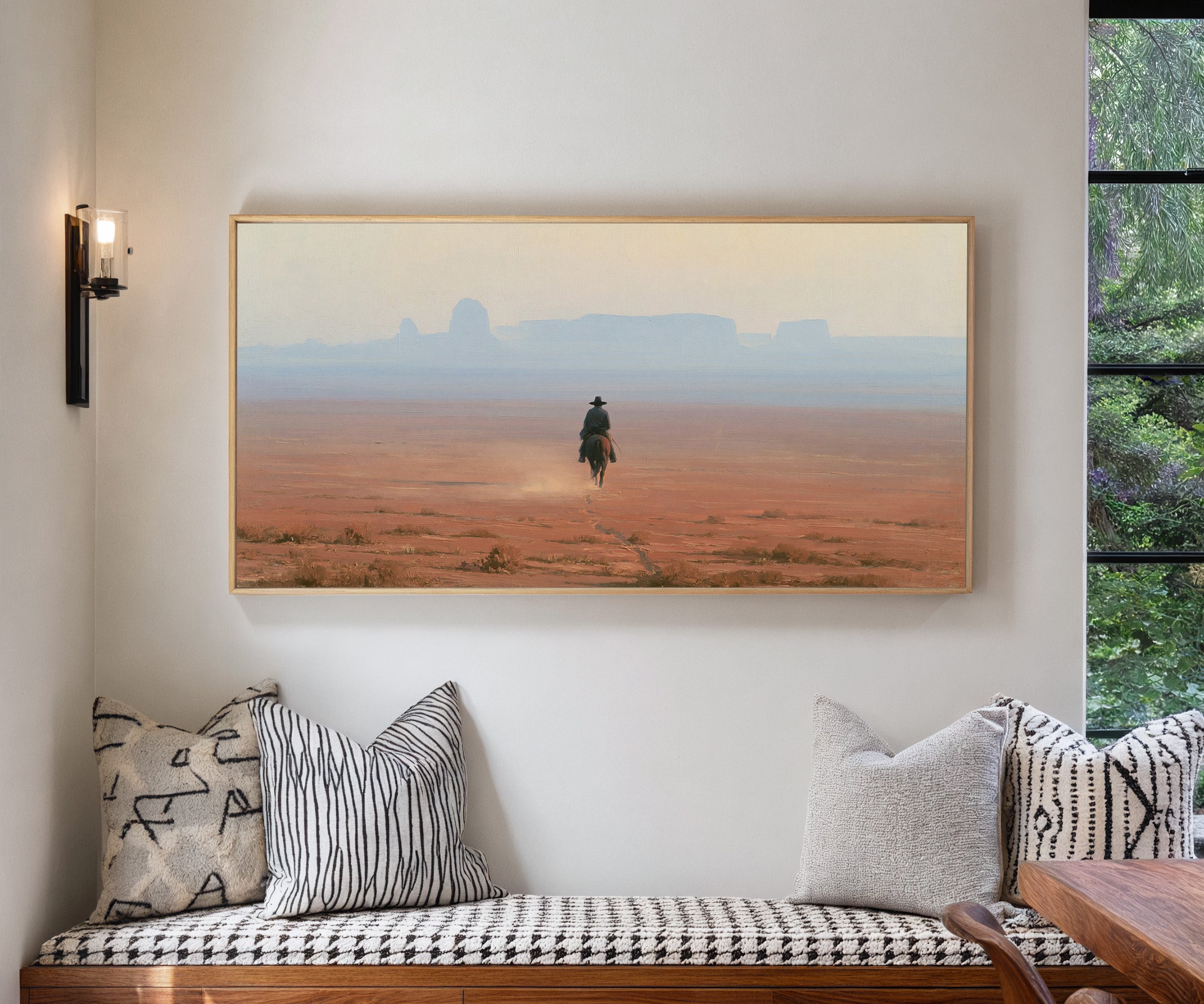 lone rider across a red desert plain with pale canvas wall art in a natural wood frame in a living room