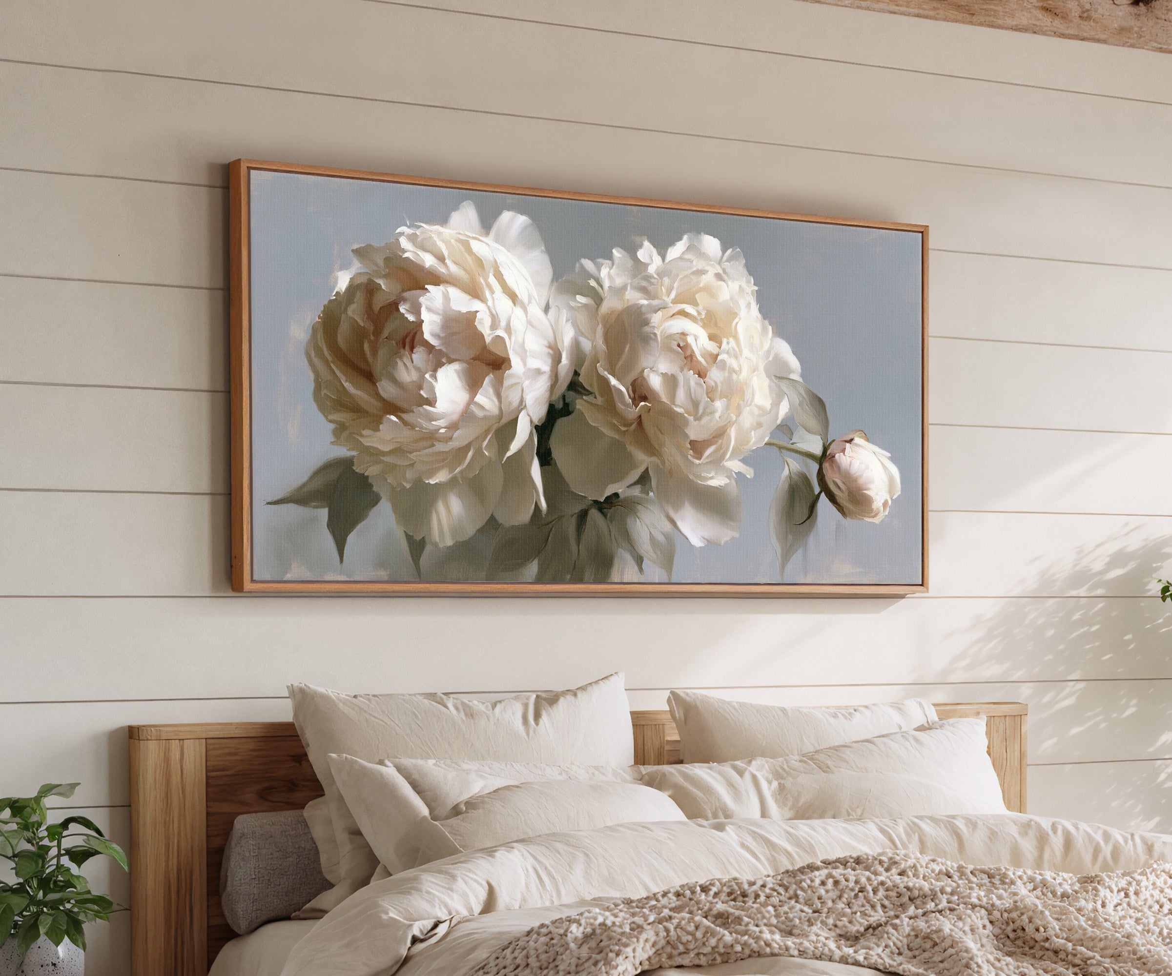 cream peonies with a single bud canvas wall art in an oak frame above a bed