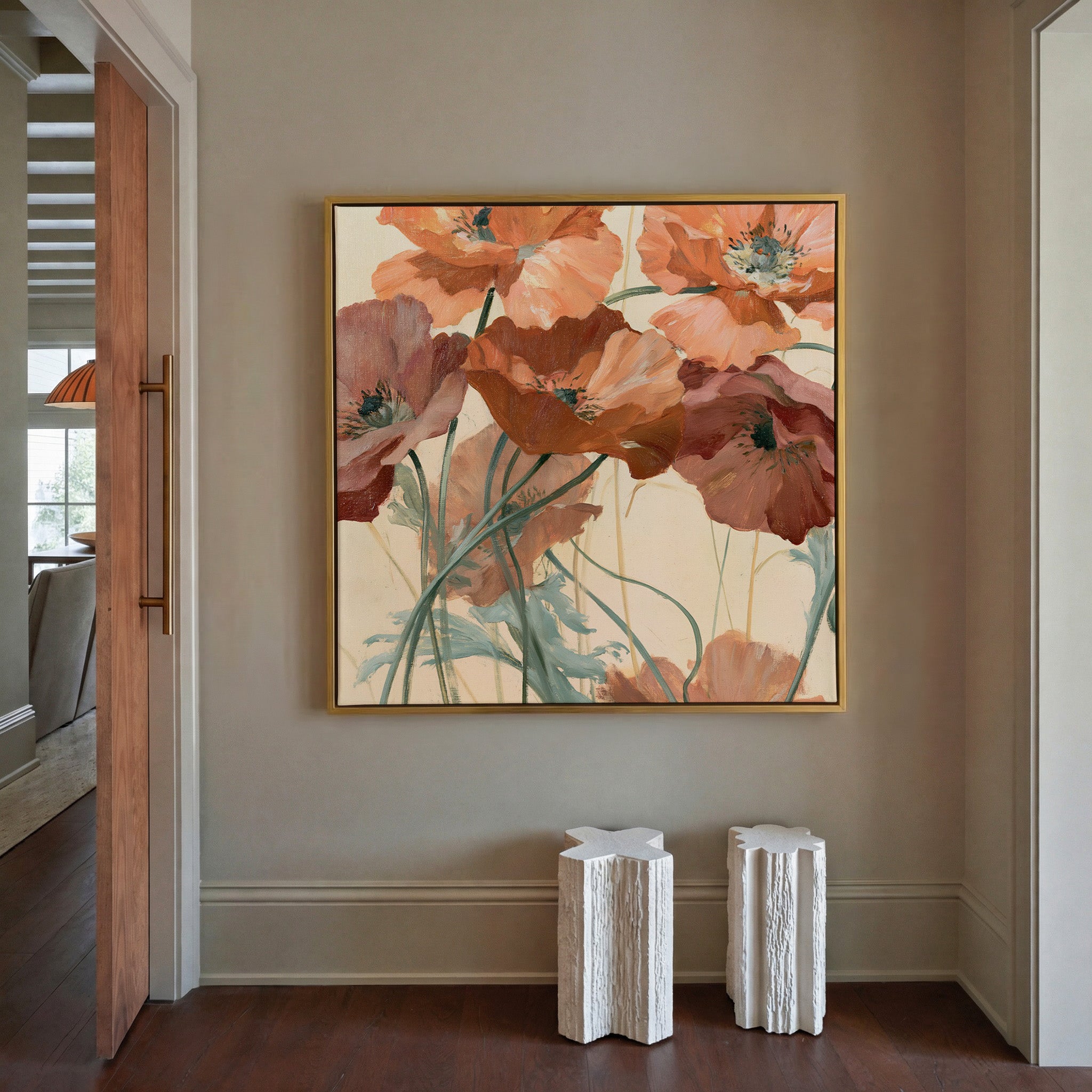 apricot and rust poppy flowers with thin green canvas wall art in a gold frame in a styled room setting