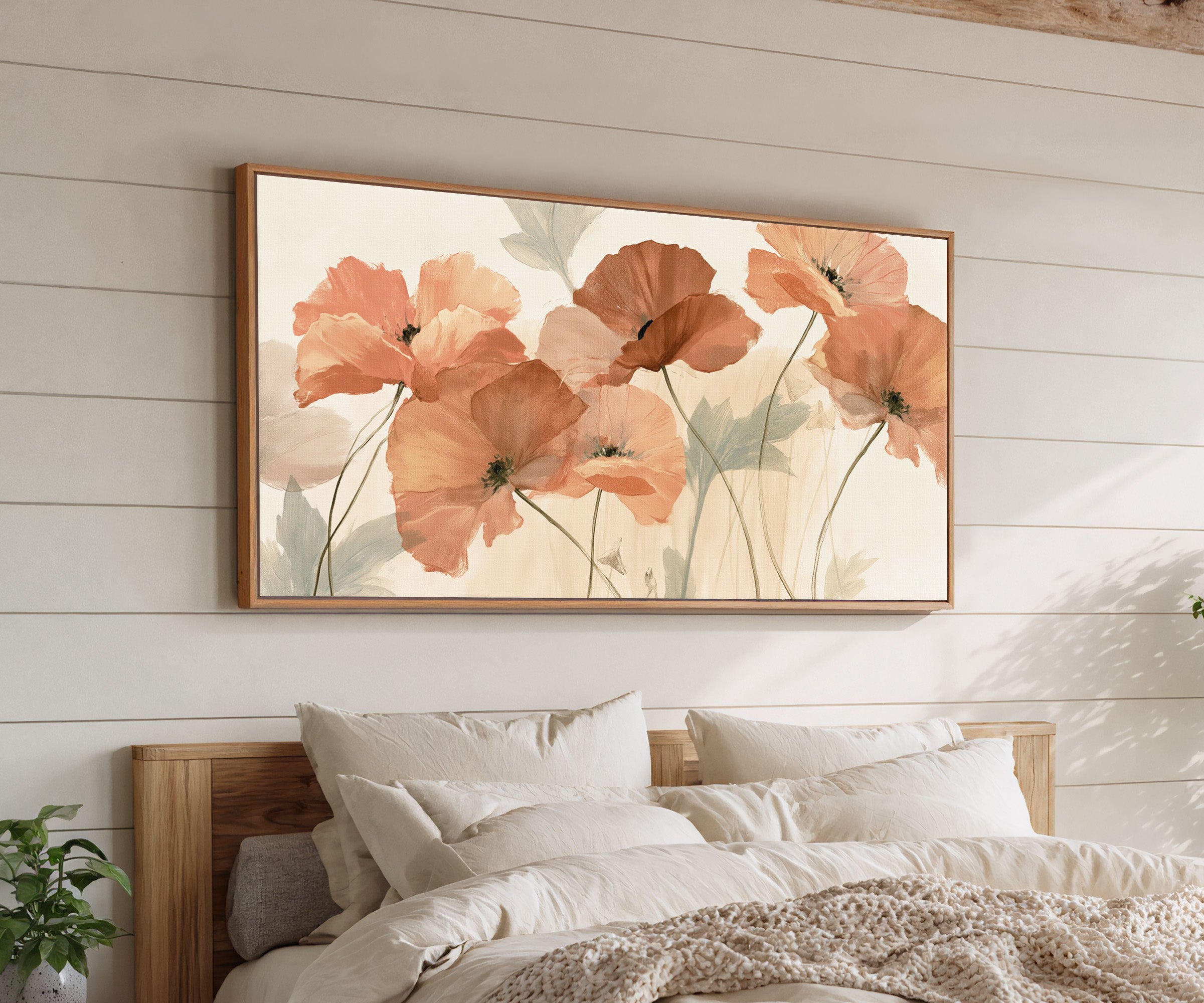 soft coral poppy flowers canvas wall art in an oak frame above a bed, with clear frame and room context