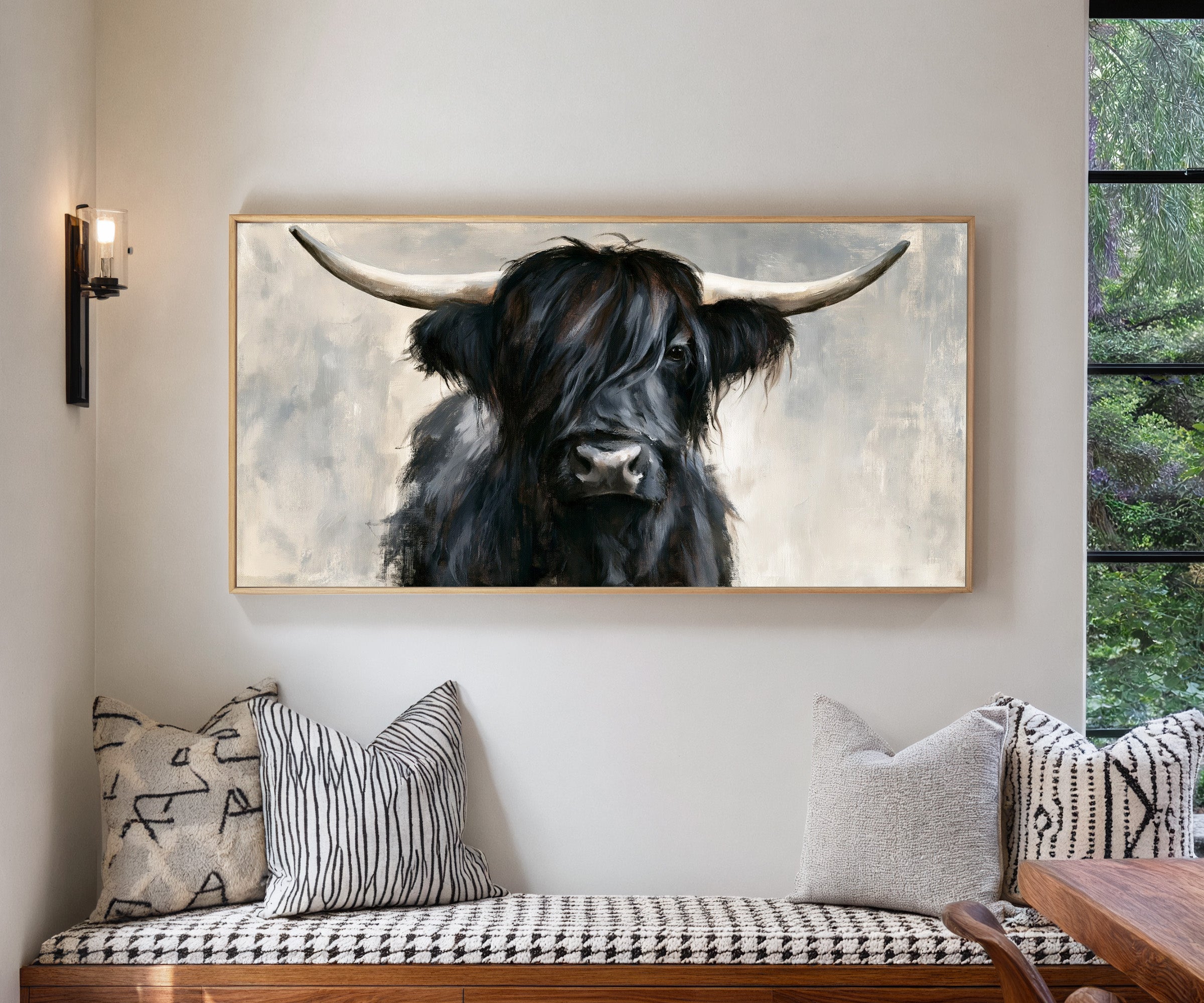 black highland cow with long shaggy hair and canvas wall art in a natural wood frame in a living room