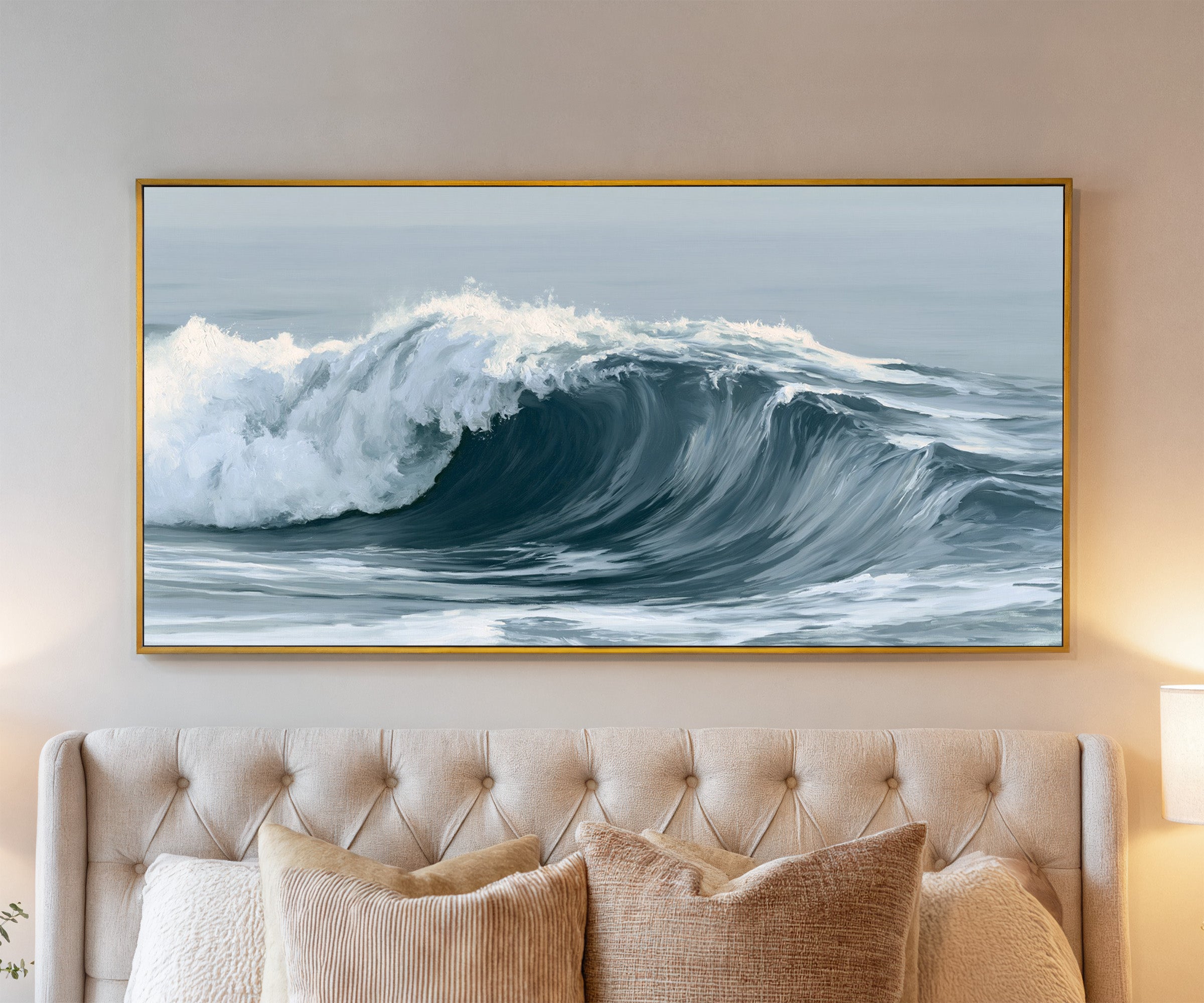 deep muted blue ocean wave canvas wall art in a gold frame above a bed