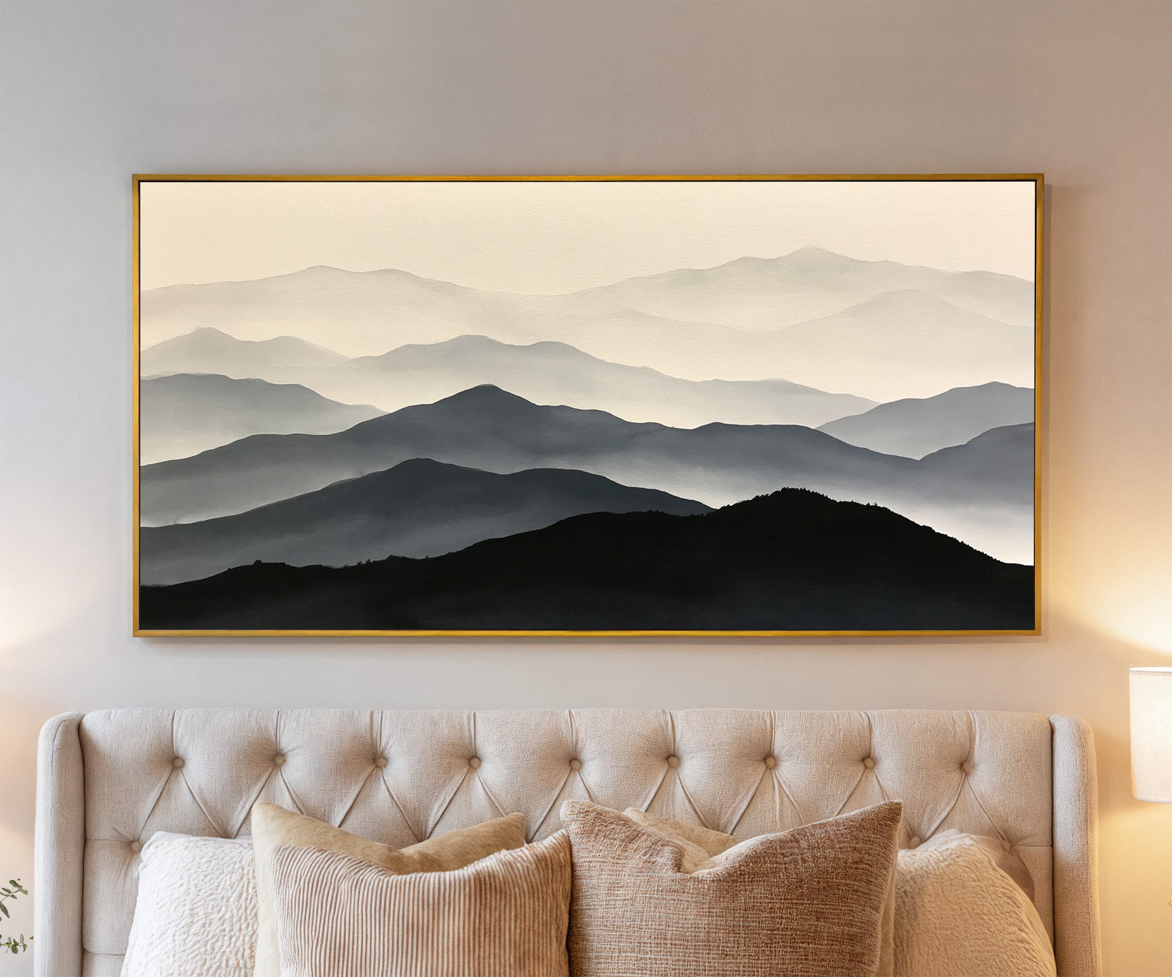 layered mountain ridges in black and gray canvas wall art in a gold frame above a bed
