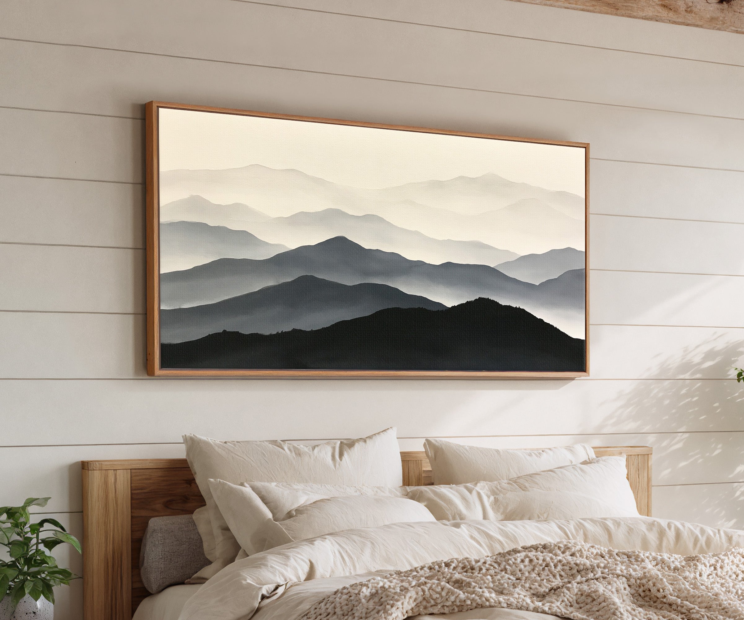 layered mountain ridges in black and gray canvas wall art in an oak frame above a bed